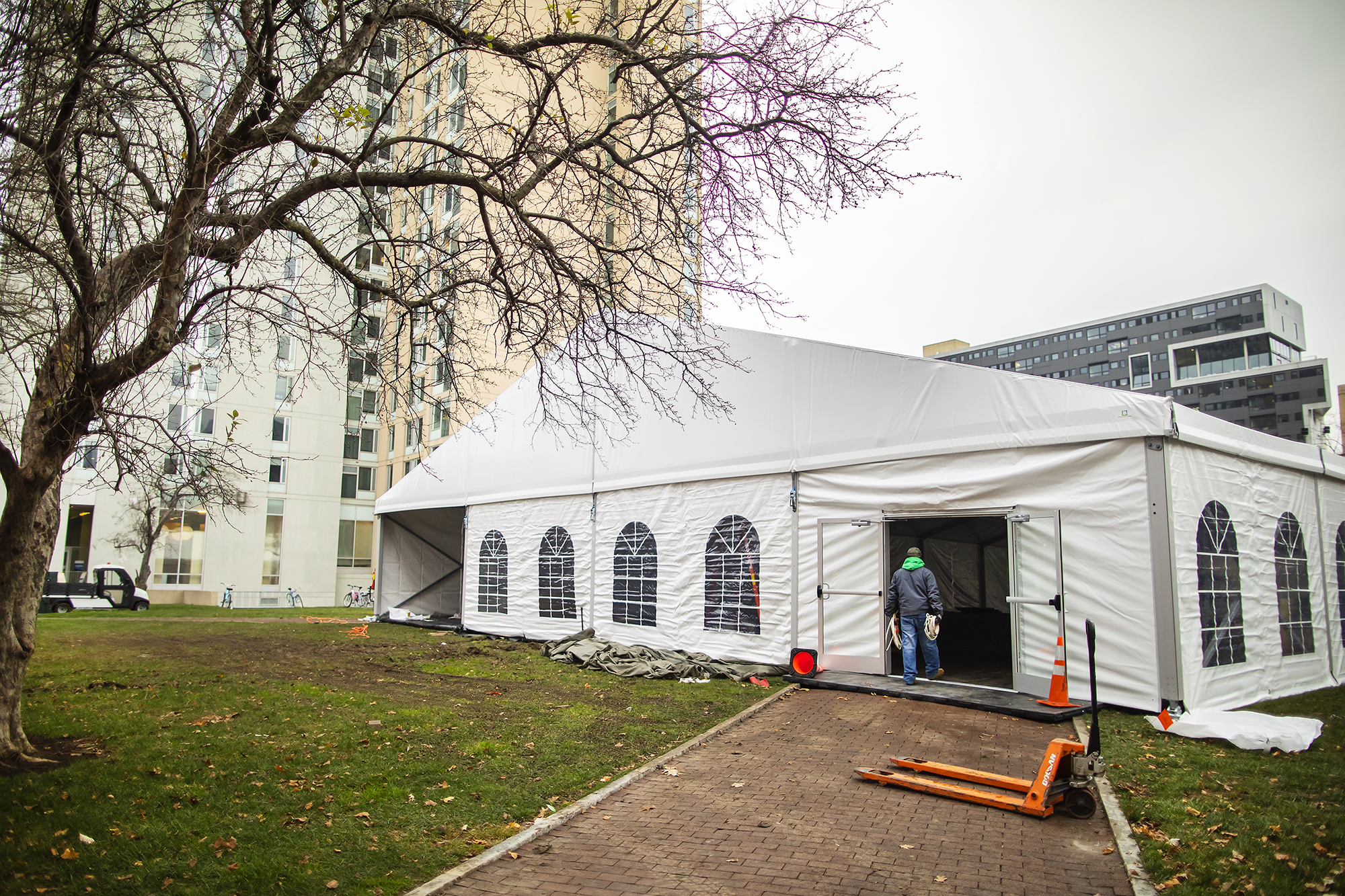 a person walking into a large outdoor tent