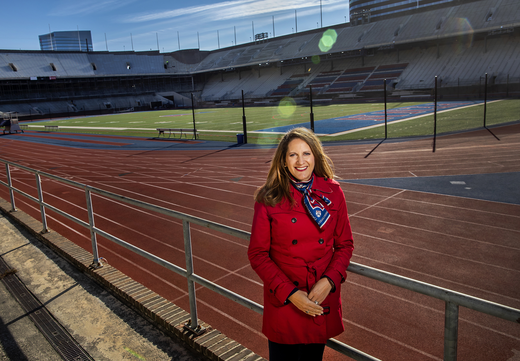 Wearing a red jacket, AD Calhoun stands in the Franklin Field bleachers.