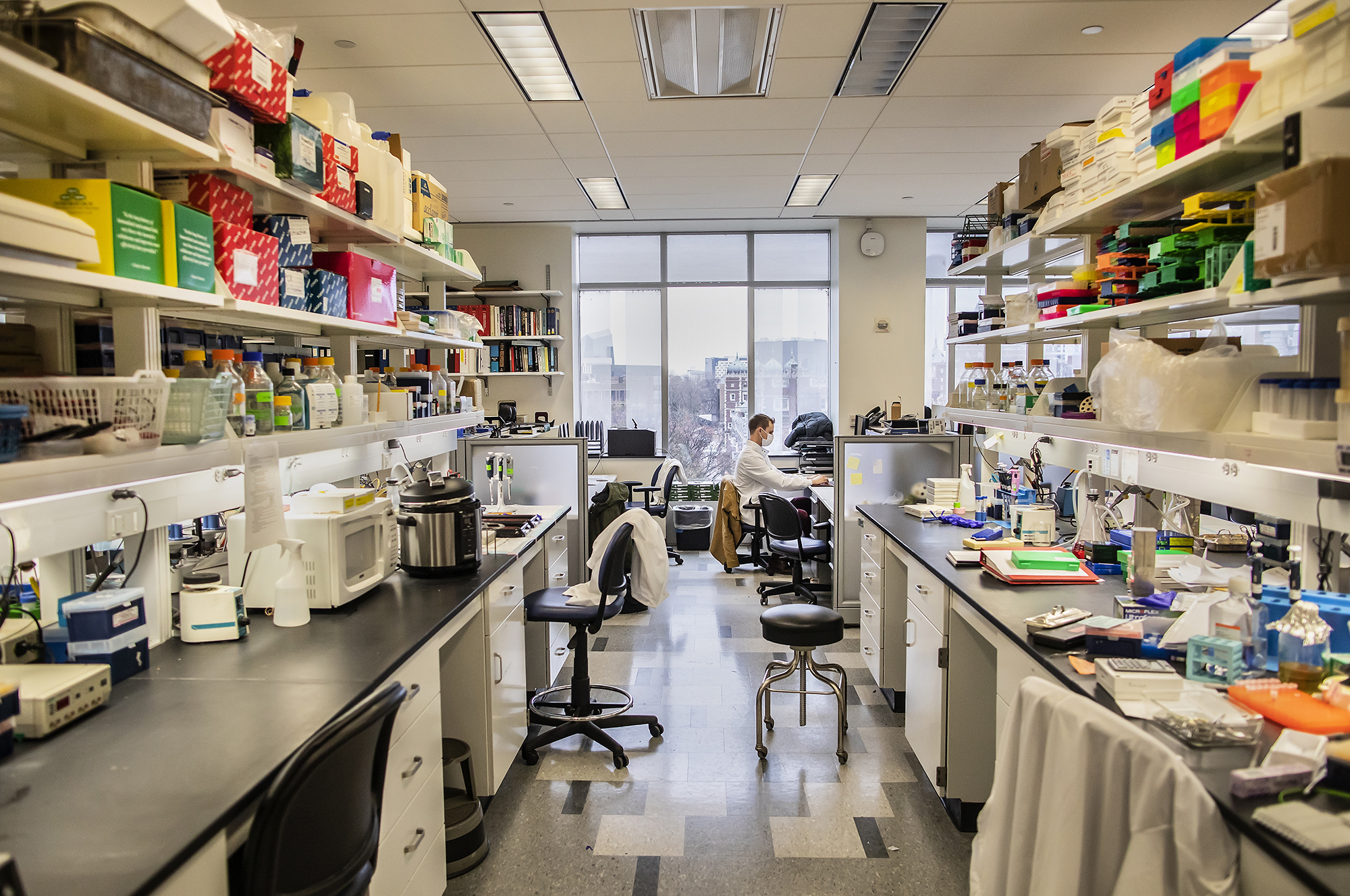 a person at the far end of a lab working on a computer