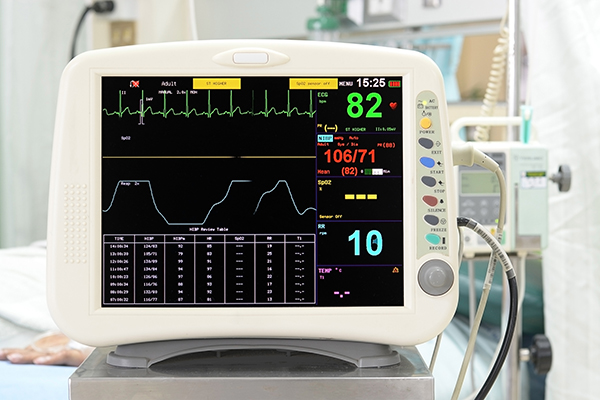 EKG monitor measuring blood pressure in a hospital room.