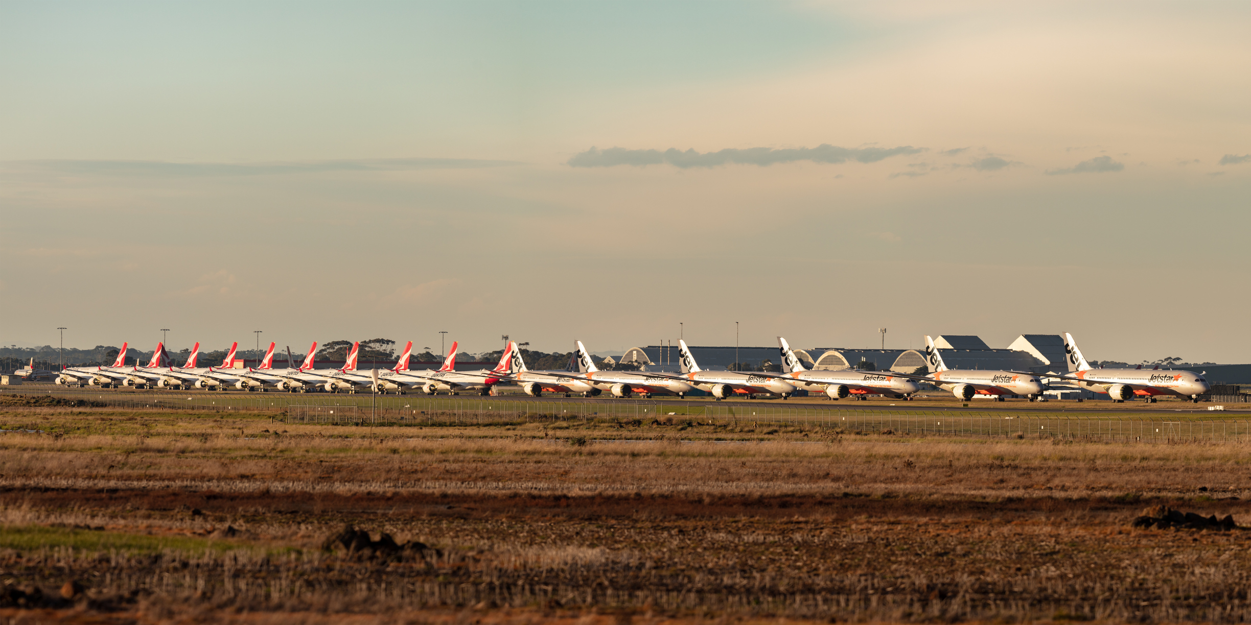 Line of airplanes parked on an airfield, grounded due to the pandemic. 