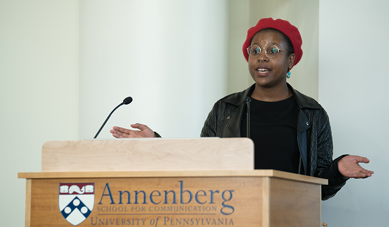 Florence Madenga speaking at a podium with Annenberg School for Communication written on the front of the podium