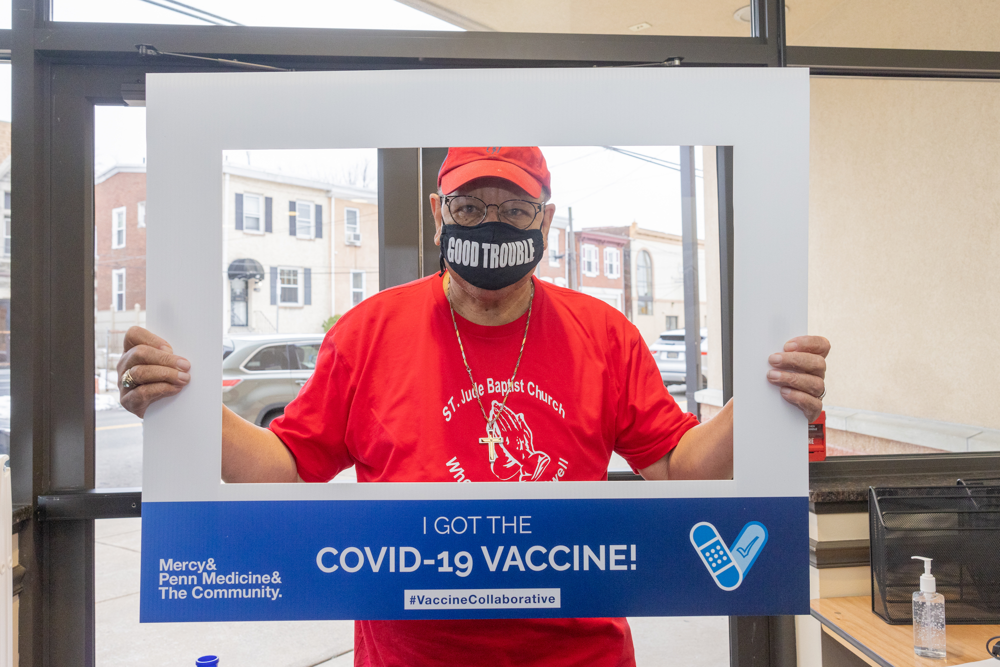 Masked person holds up photo border that reads "I got the COVID-19 vaccine!"