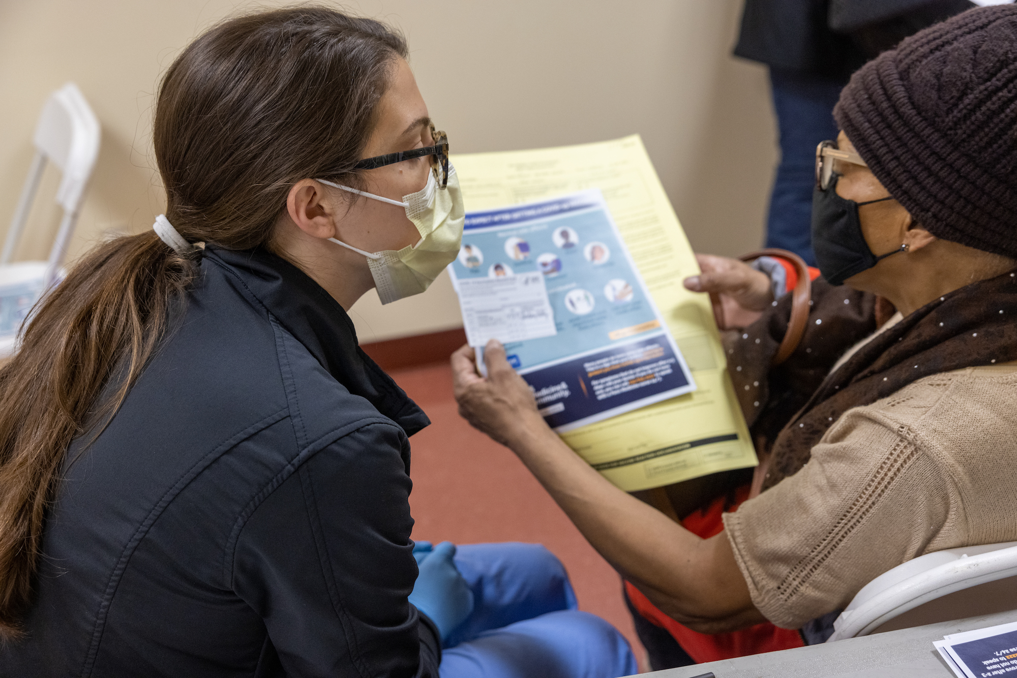 medical professional gives informational materials to a patient