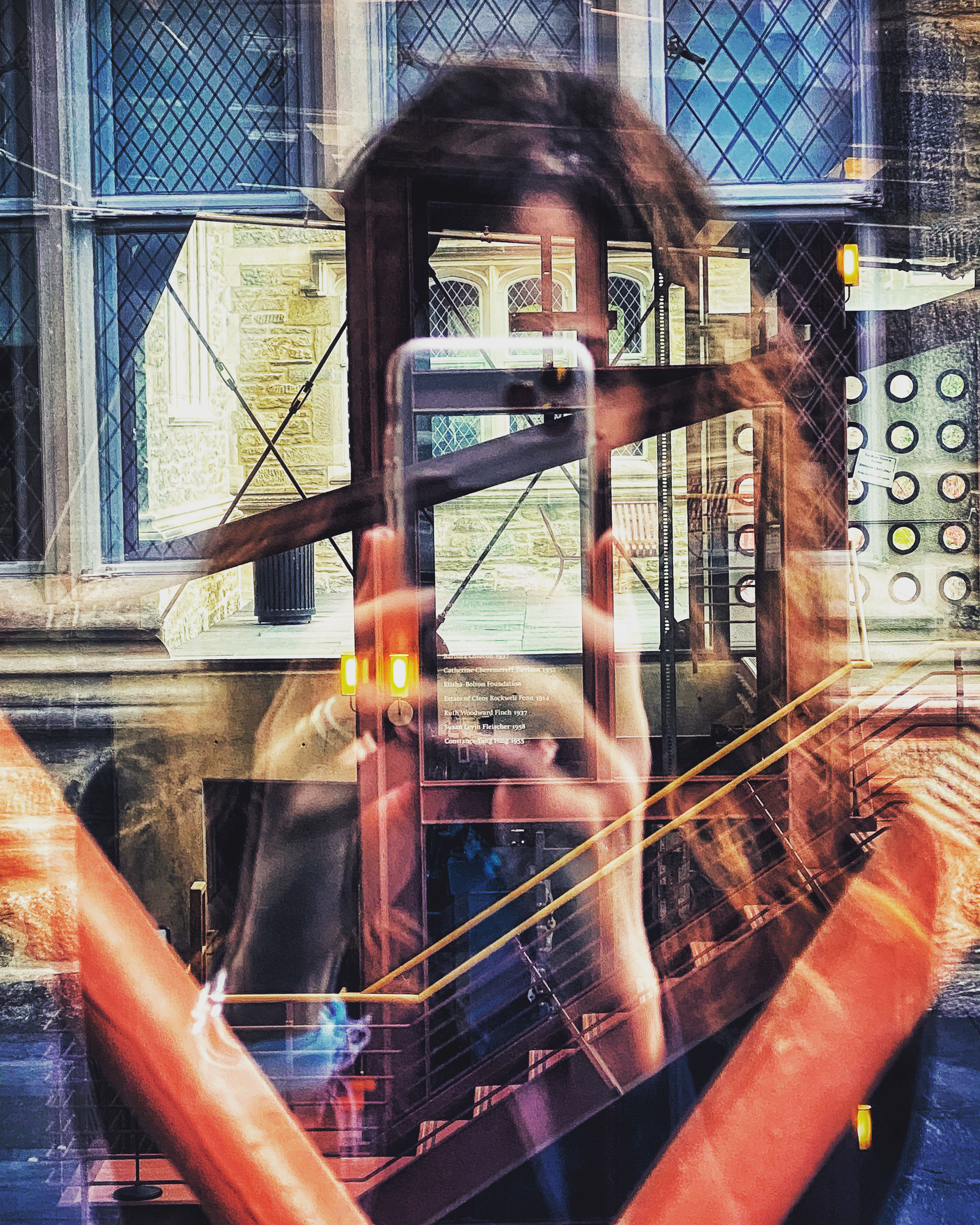 A layered image of a person holding a cell phone beneath blurring of buildings and windows and doors.