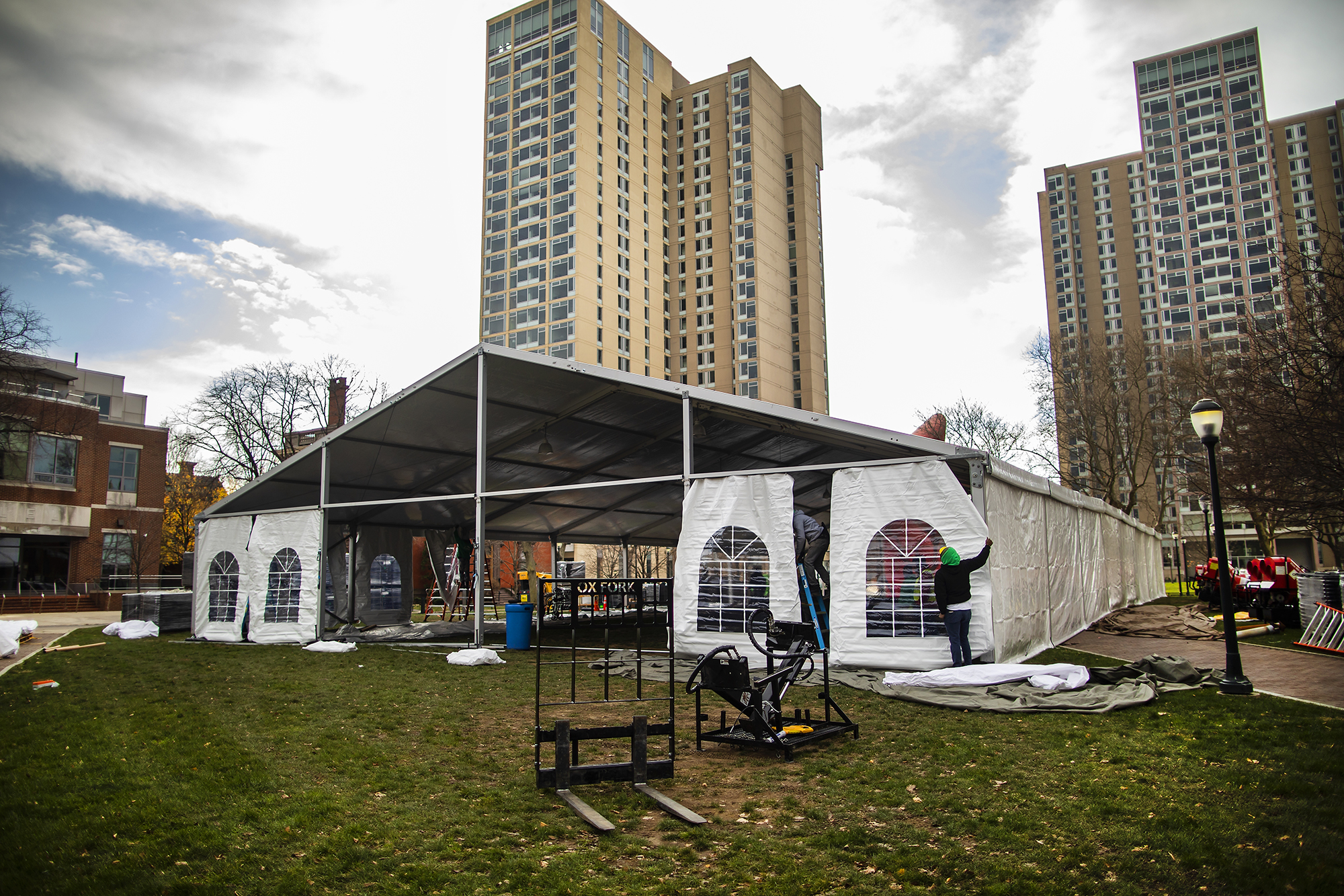 Workers erect an outside COVID-testing site tent at the top of Locust Walk.