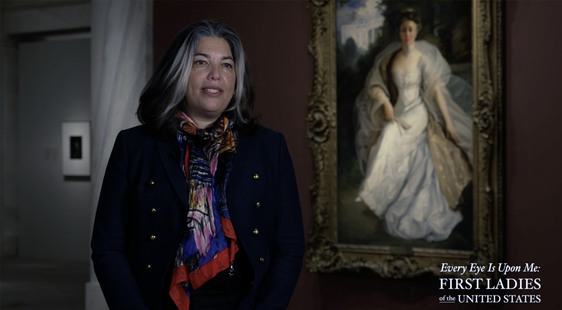Professor standing in front of a portrait in a museum gallery