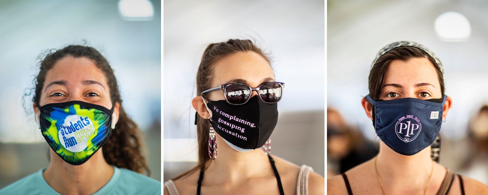 Three people on Penn’s campus wearing masks with logos and words.