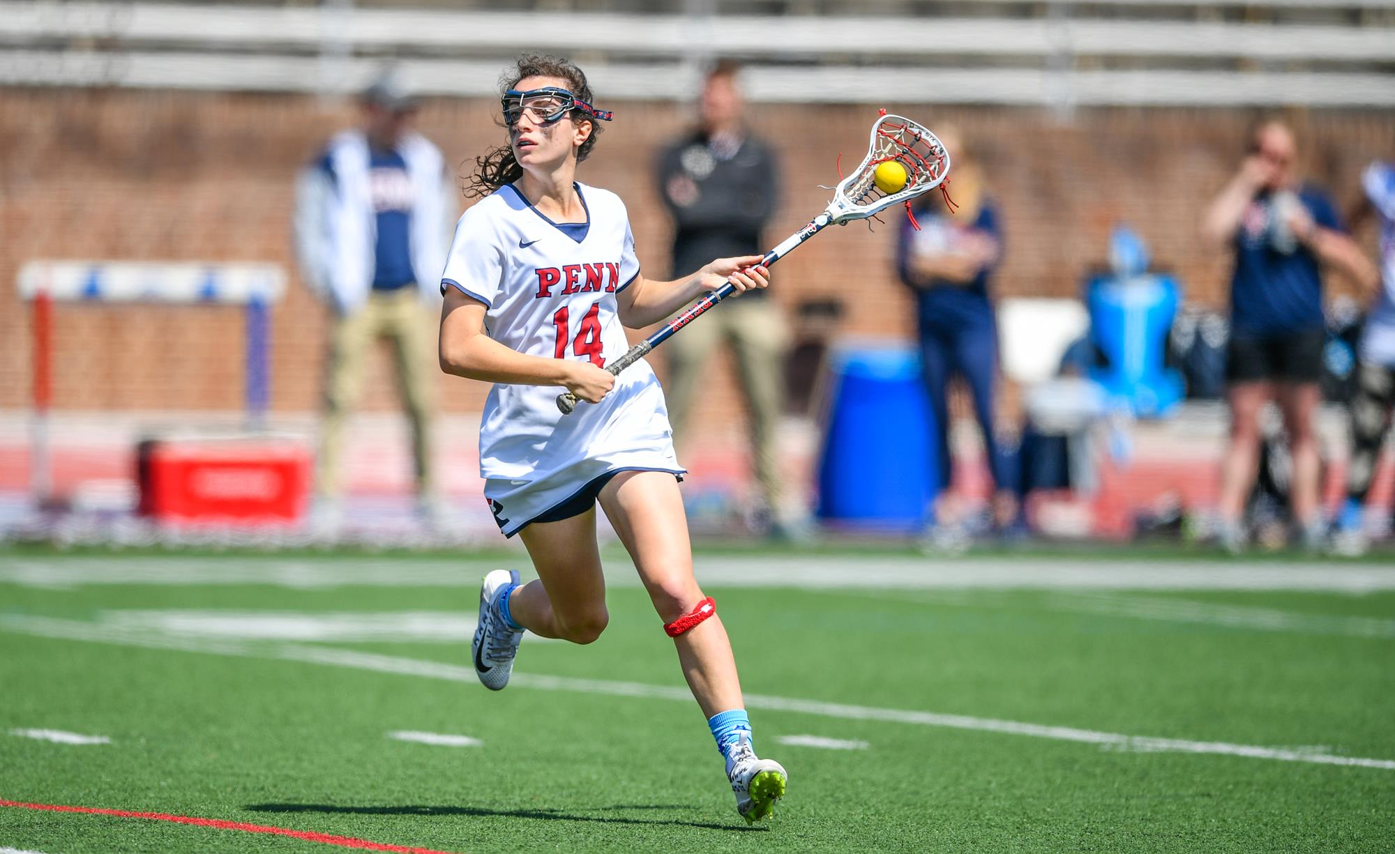 Zoe Belodeau surveys the field with the ball in her stick during a game.