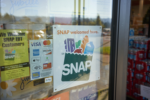 Sign in grocery store windows indicating that SNAP is welcomed there.