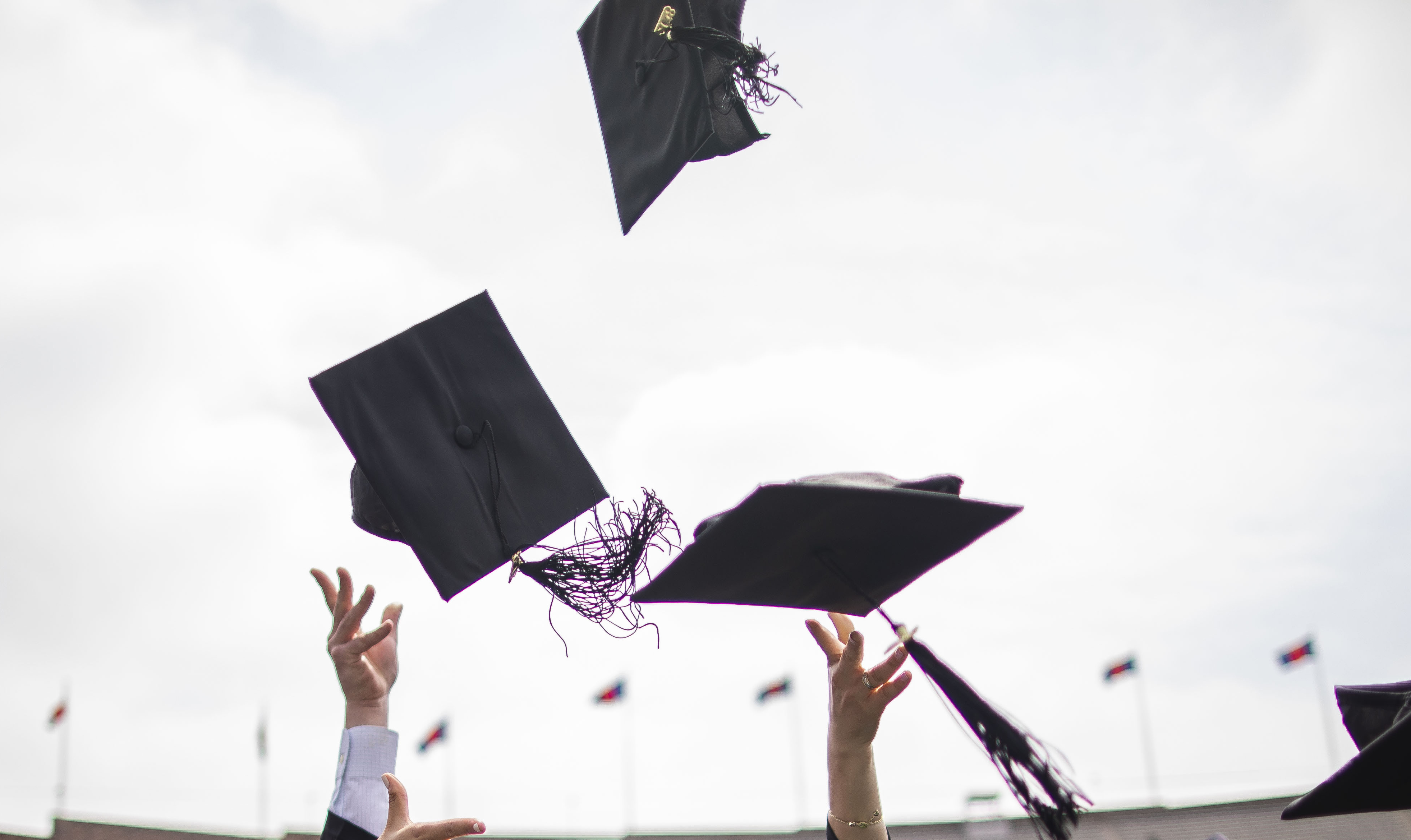 Graduation caps thrown in air