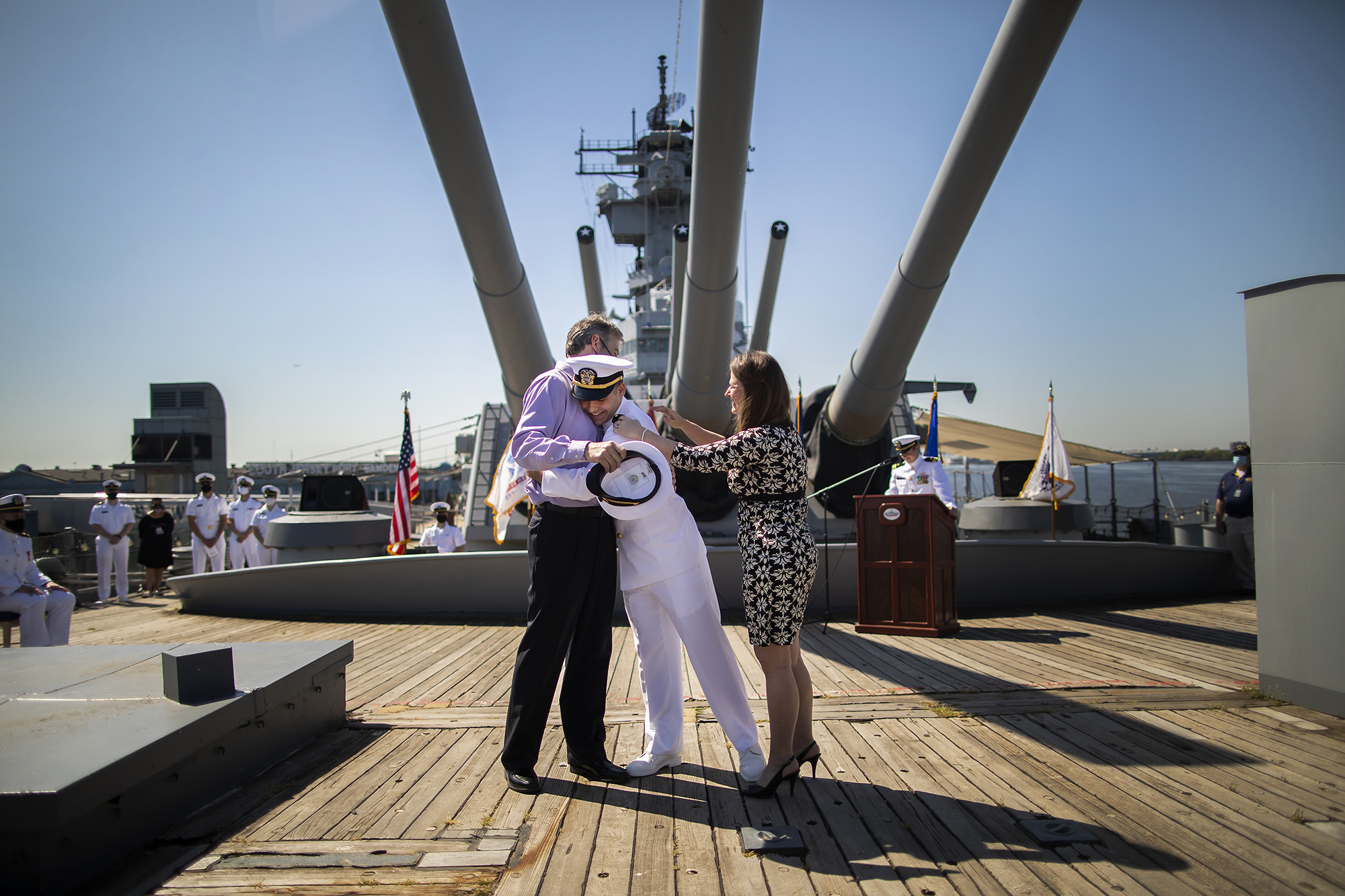 Person in uniform hugs their parents aboard the USS New Jersey.