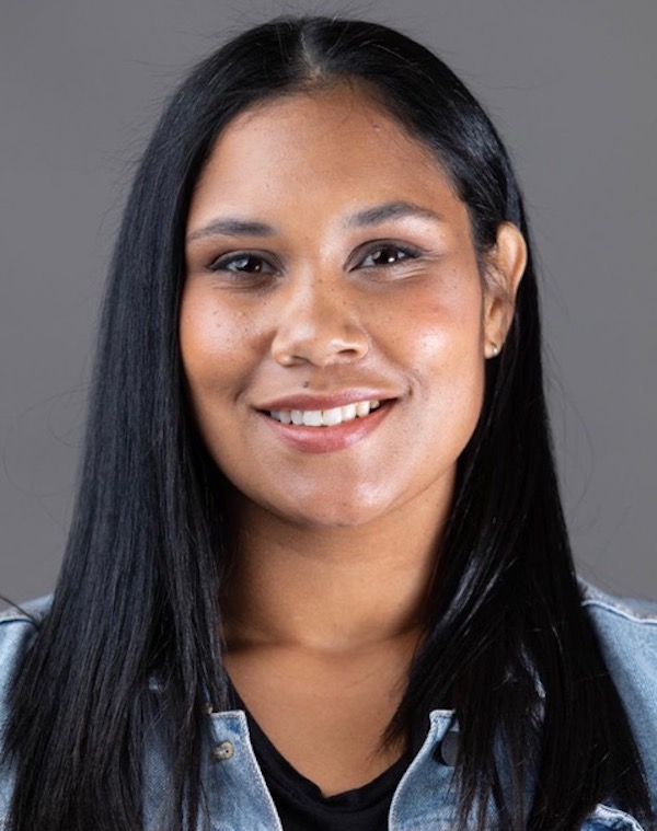 Headshot of woman with long straight black hair shows her smiling into the camera