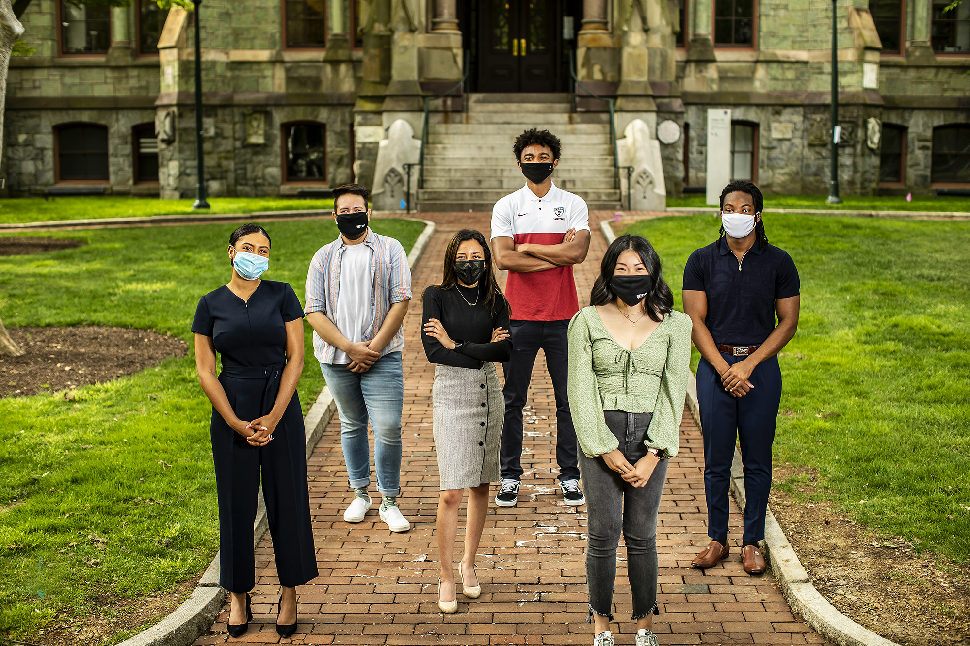 Six students standing outside College Hall wearing masks