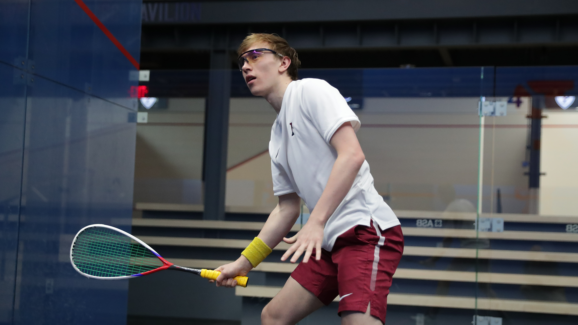 Andrew Douglas stands with his racquet extended to the left during a squash match.