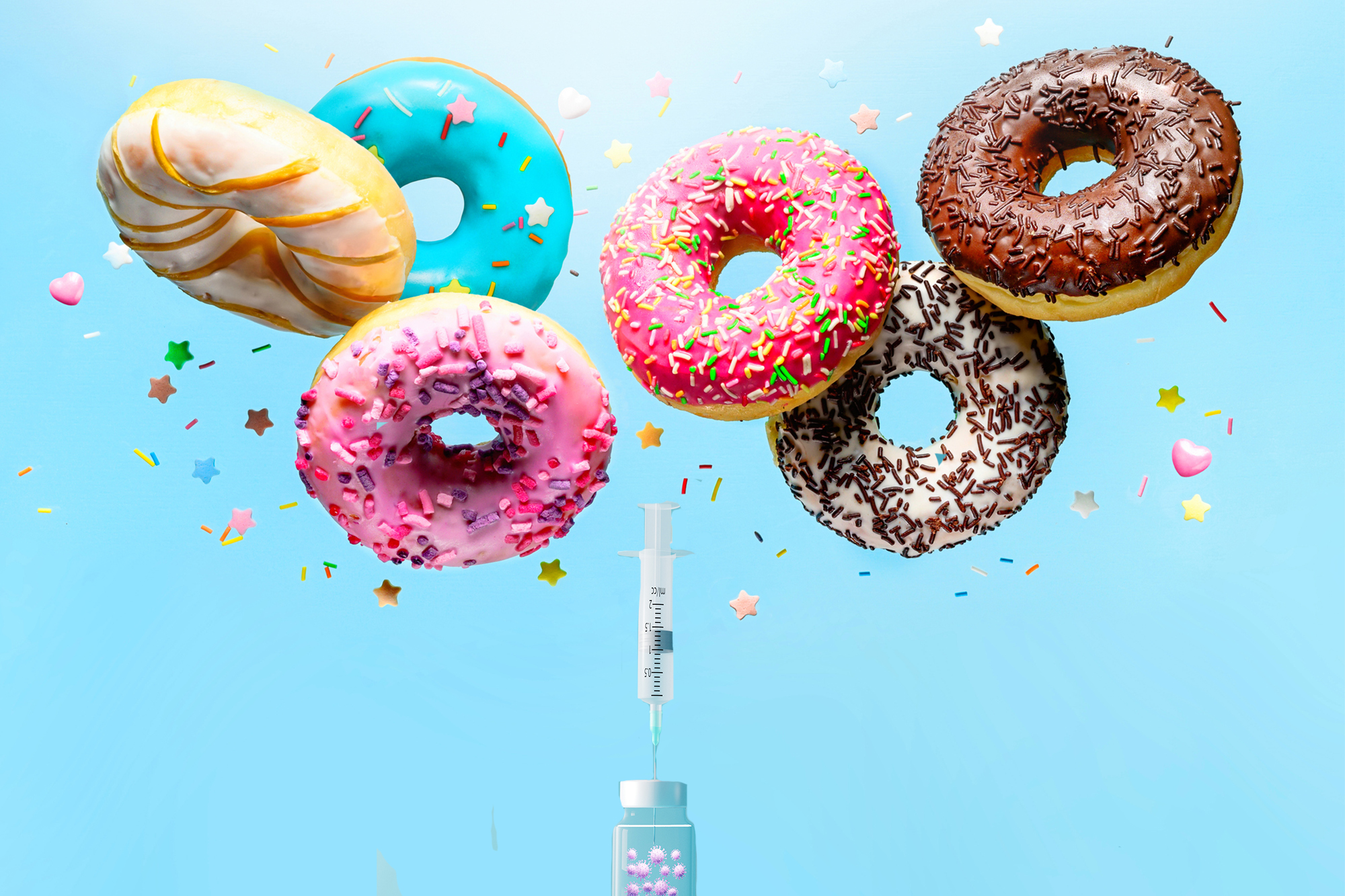 Sprinkle donuts falling from sky over a vial of vaccine and a needle.