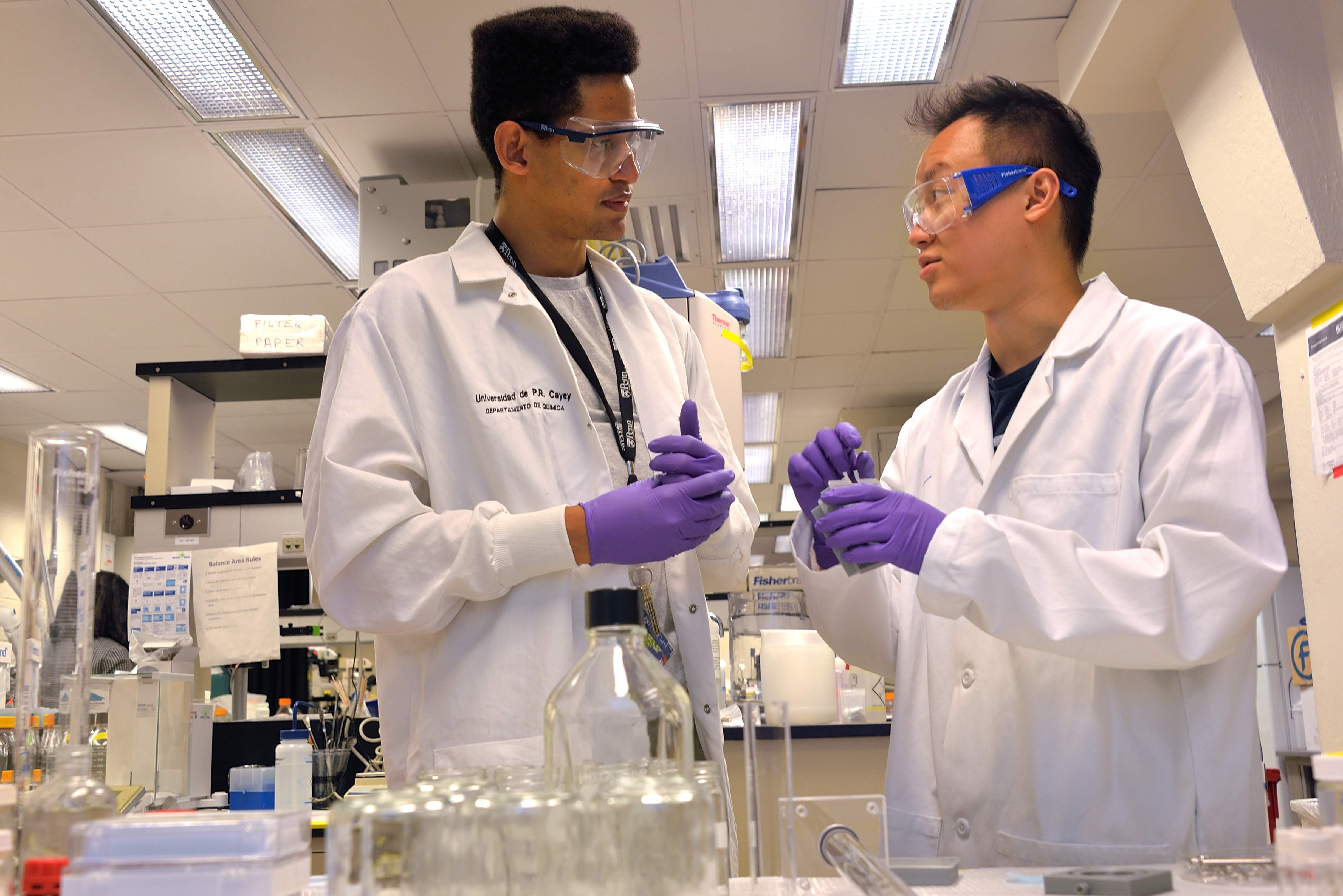 two people talking to each other inside of a research lab