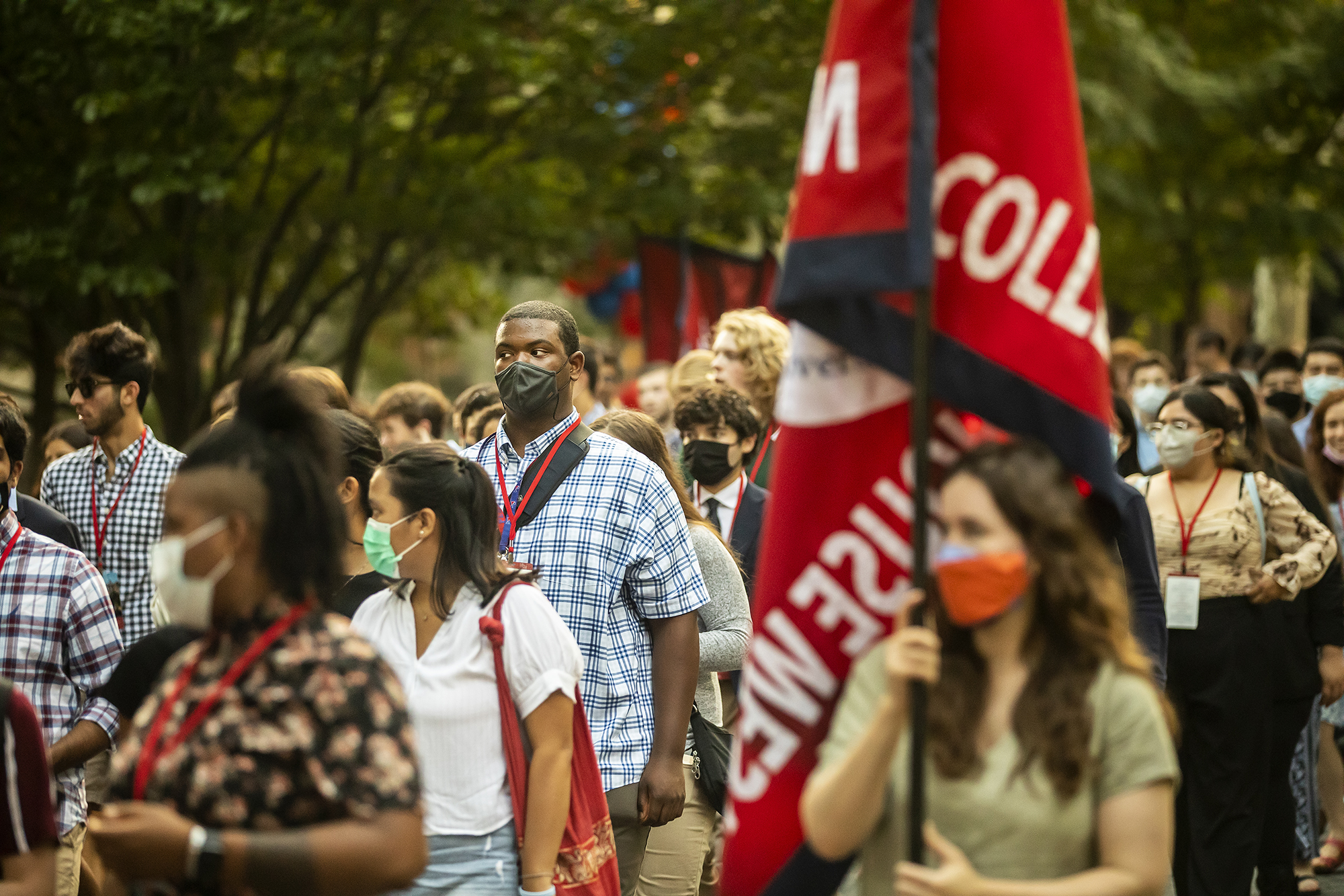 Students carrying college house flags march across campus to the 2021 Convocation ceremony