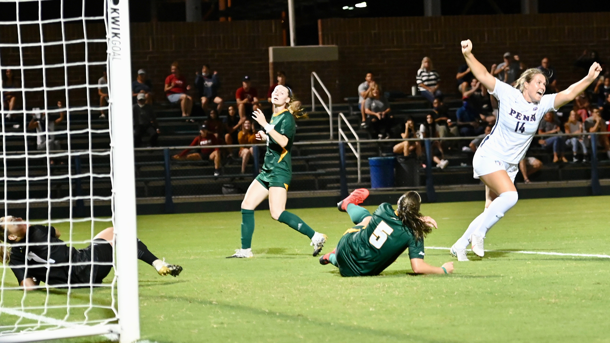 A Penn player celebrates with her arms raised after scoring a goal.