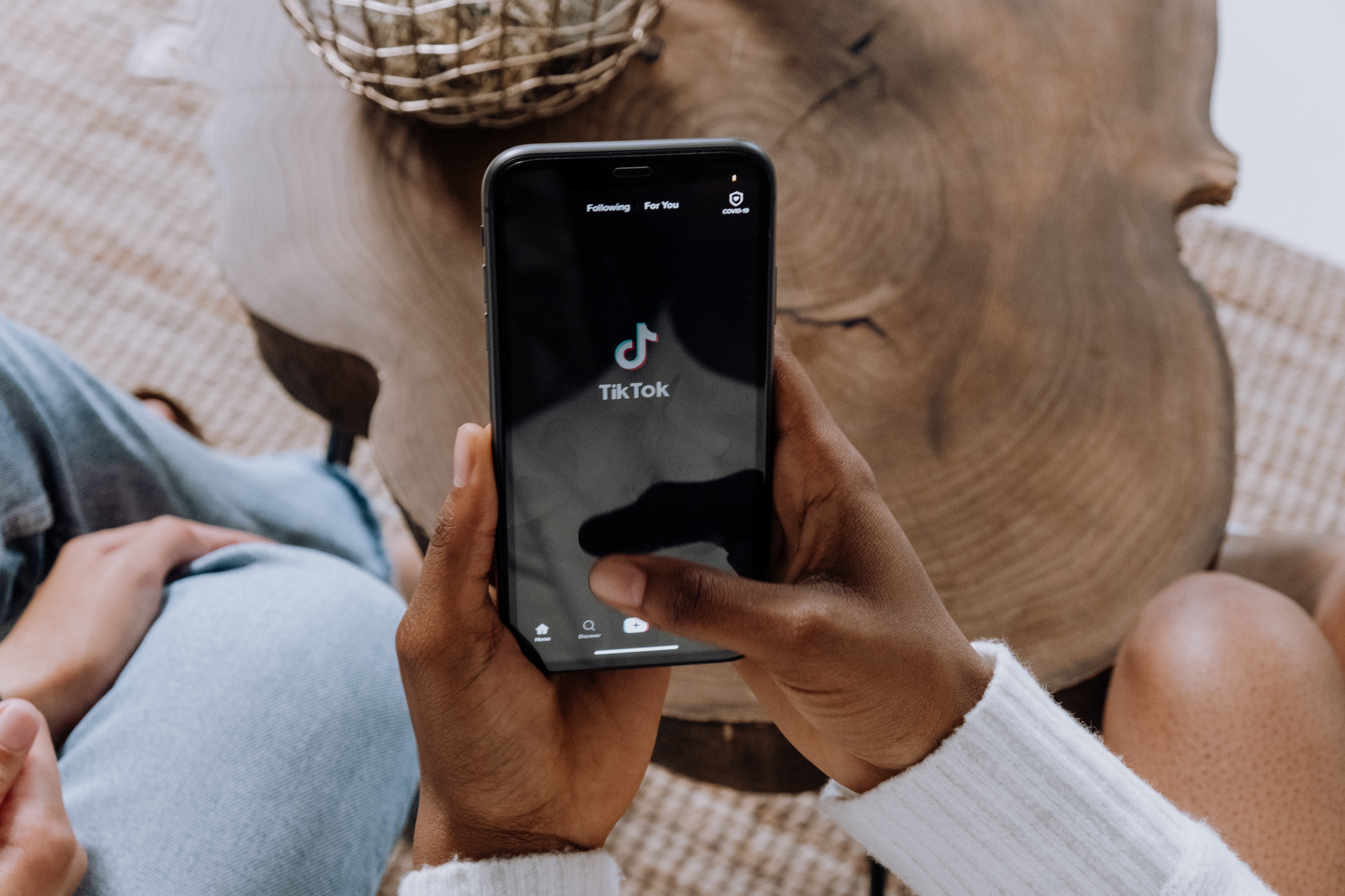 Two people sitting together looking at a phone with a TikTok logo