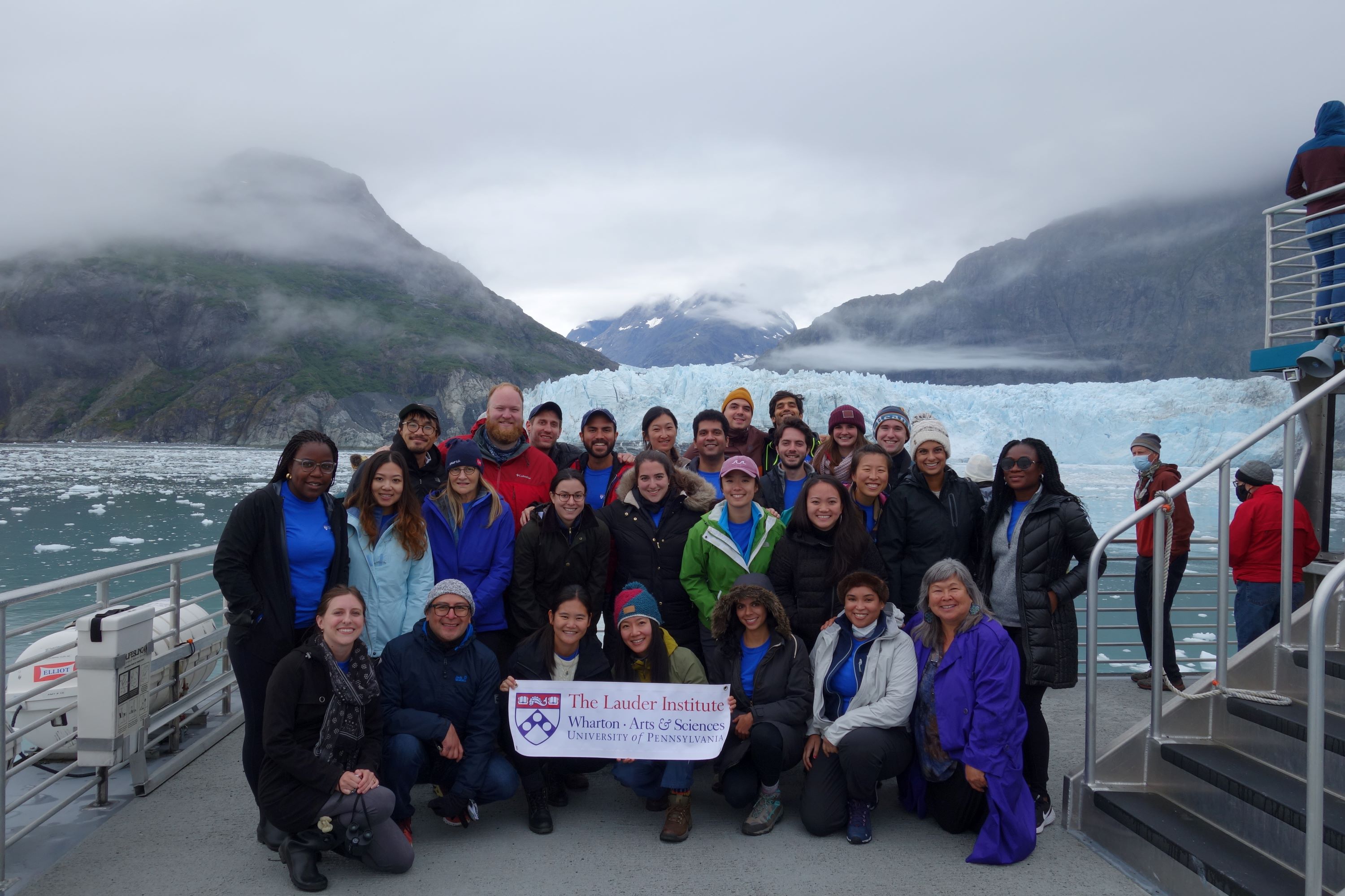Lauder students posing on a ship in front of a glacier