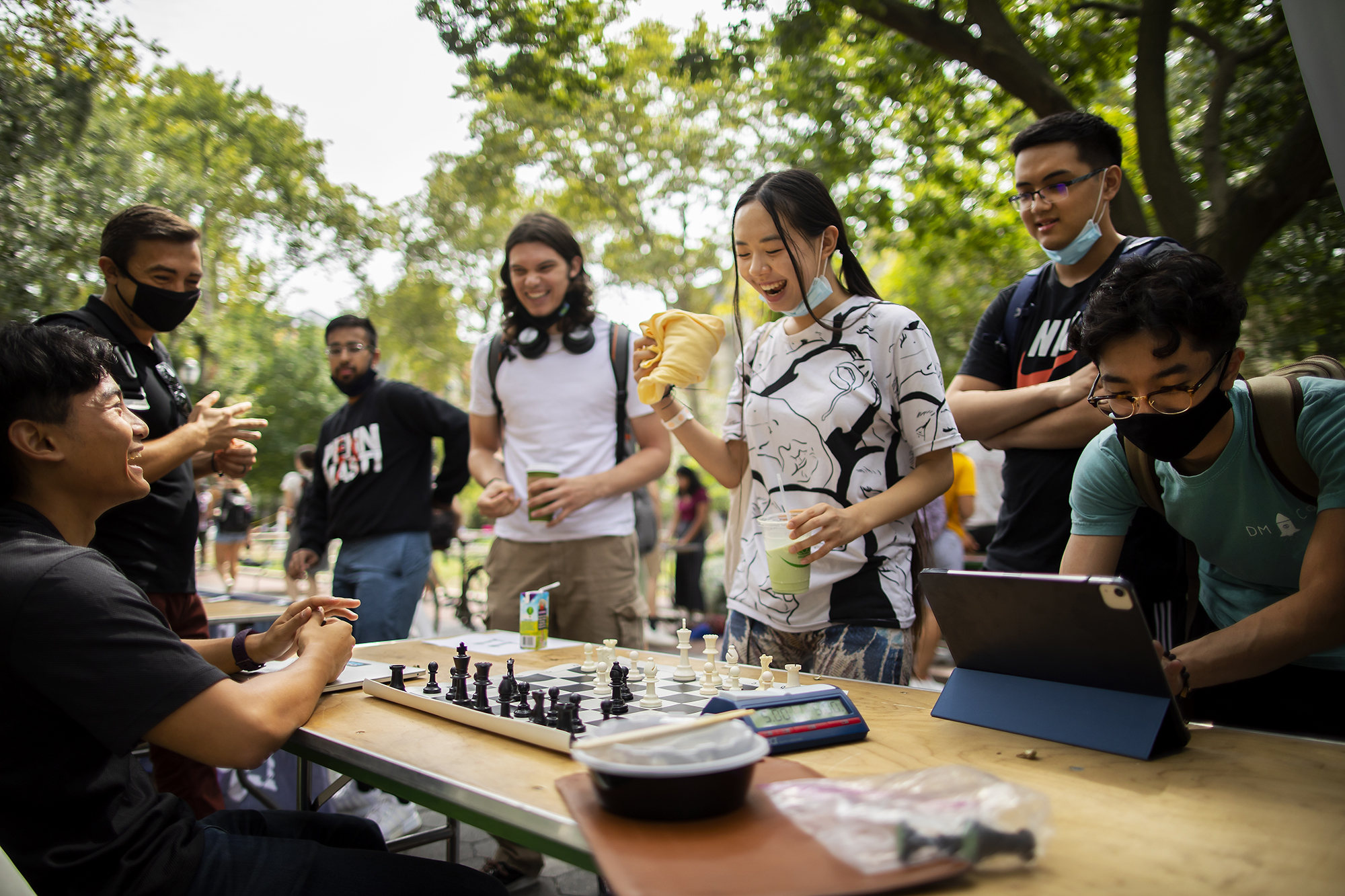 students playing chess at a table outside