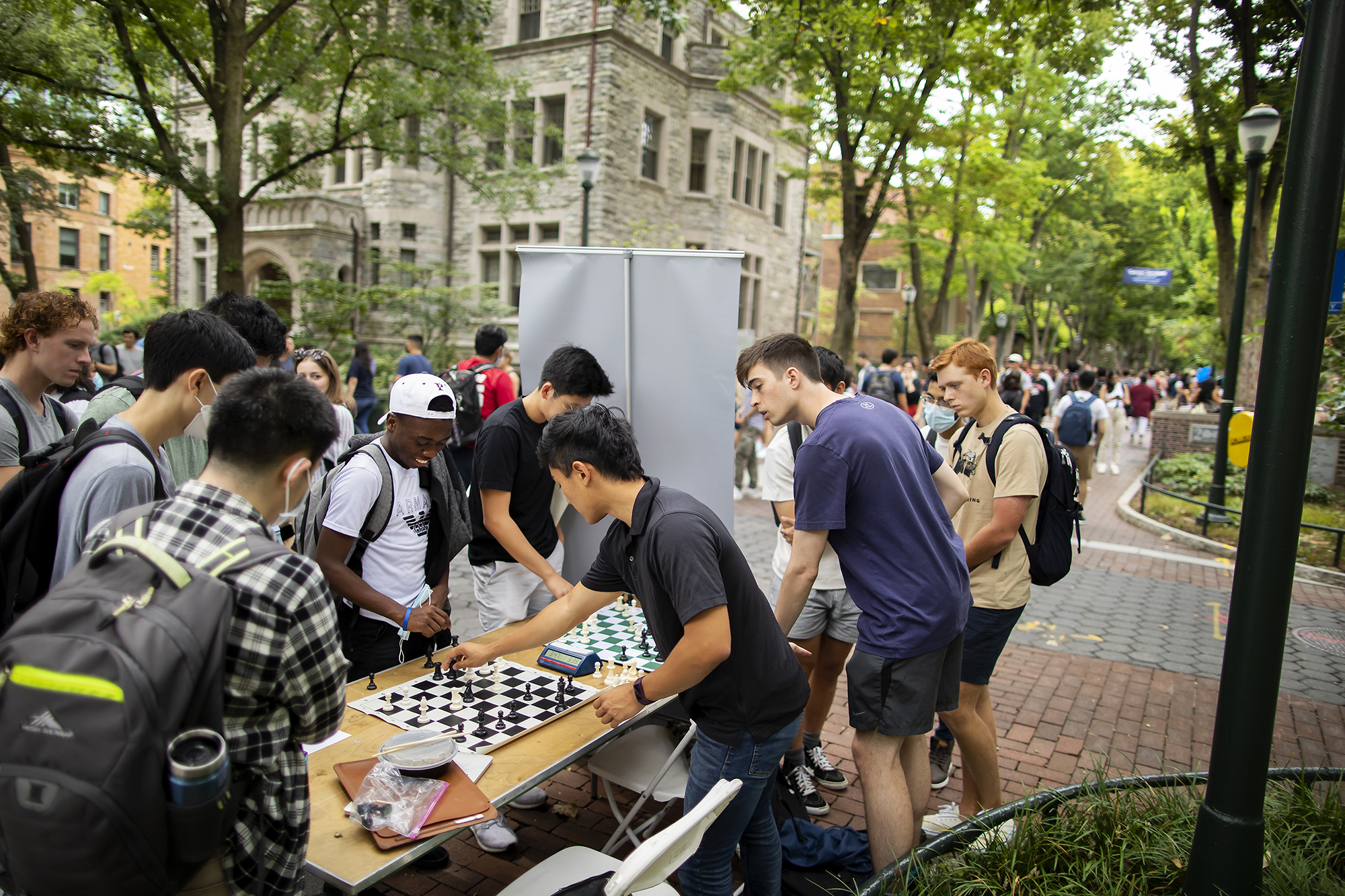 students playing chess on a table outside