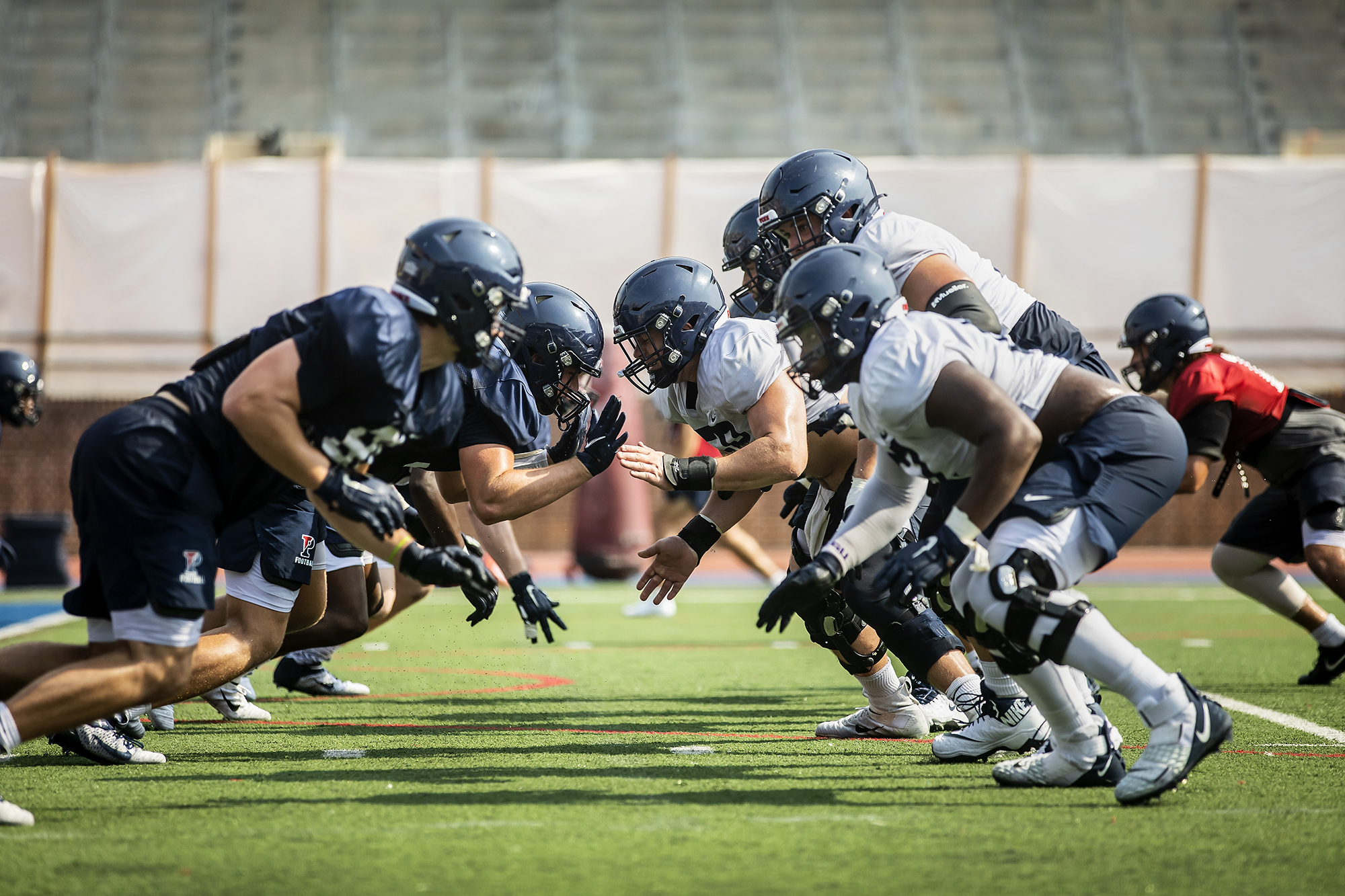 Offensive linemen and defensive linemen battle at the line of scrimmage.