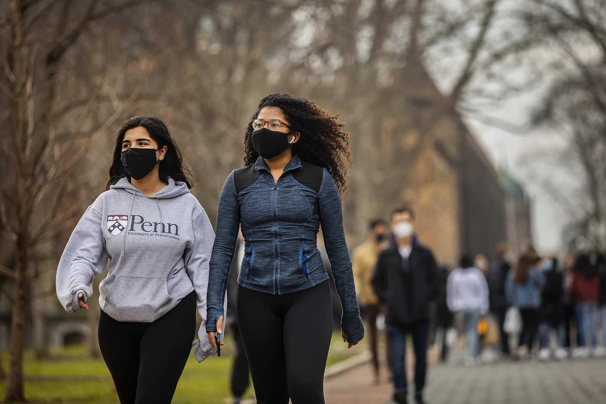 two people walking on campus with face coverings