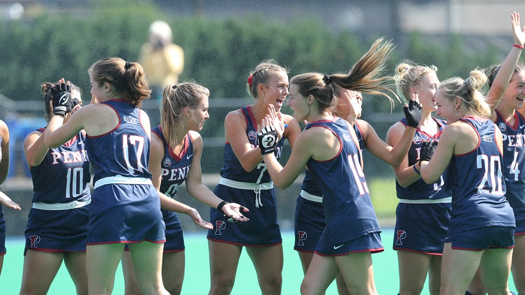 Members of the field hockey teams clap hands during a line.