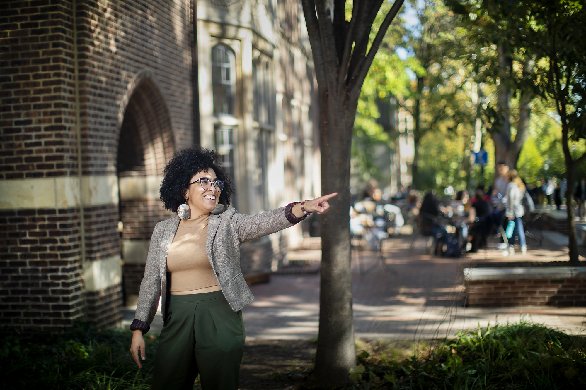 Woman stands and points outside the ARCH building