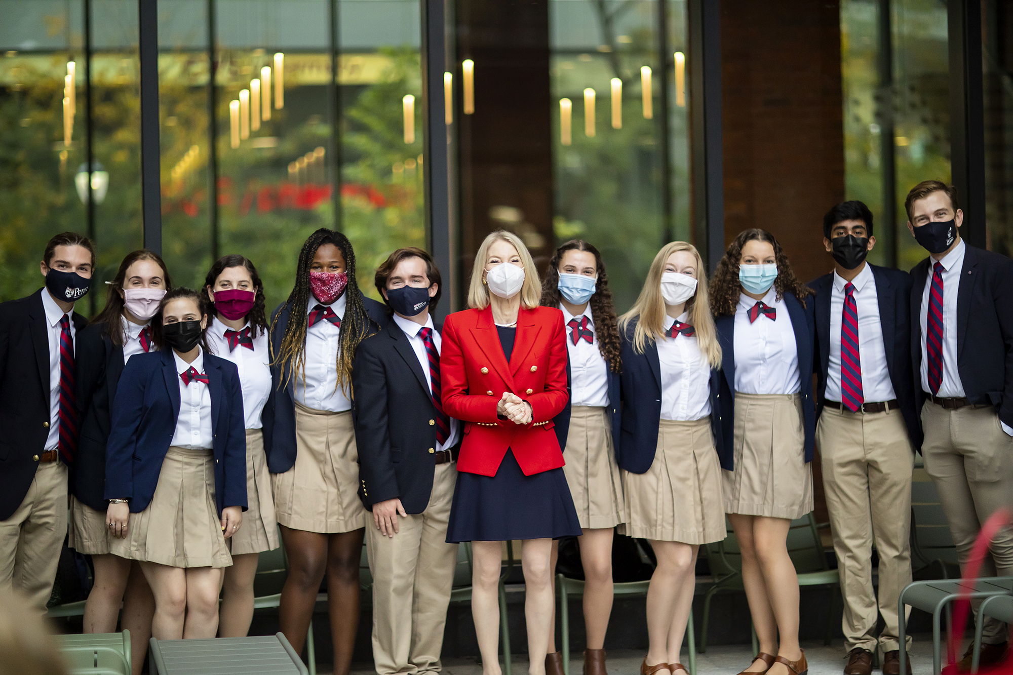 President Amy Gutmann standing with 11 members of the Penn Glee Club