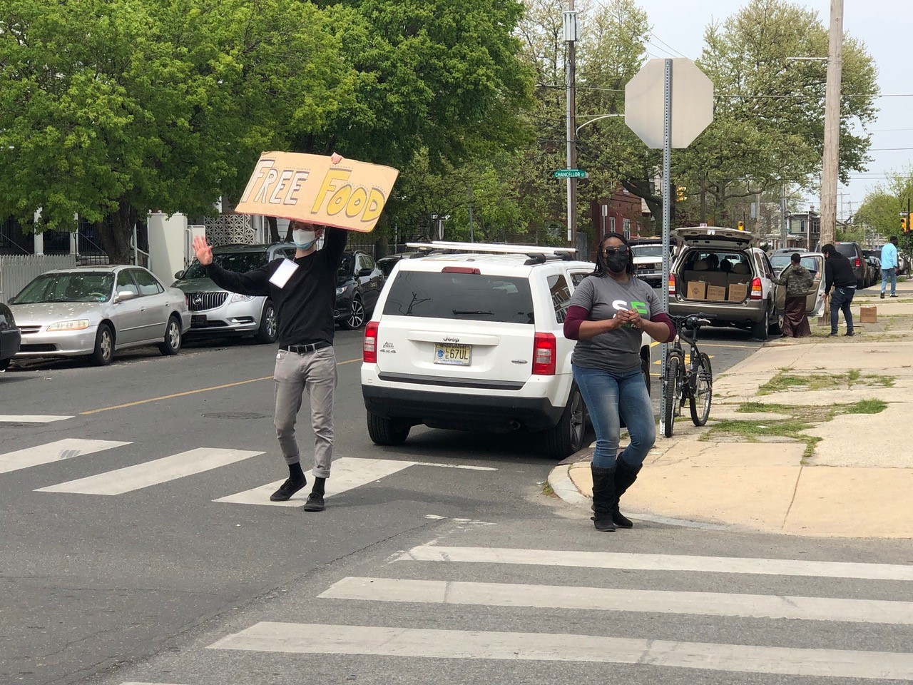 Person holds up sign that says "Free Food" at a distribution event