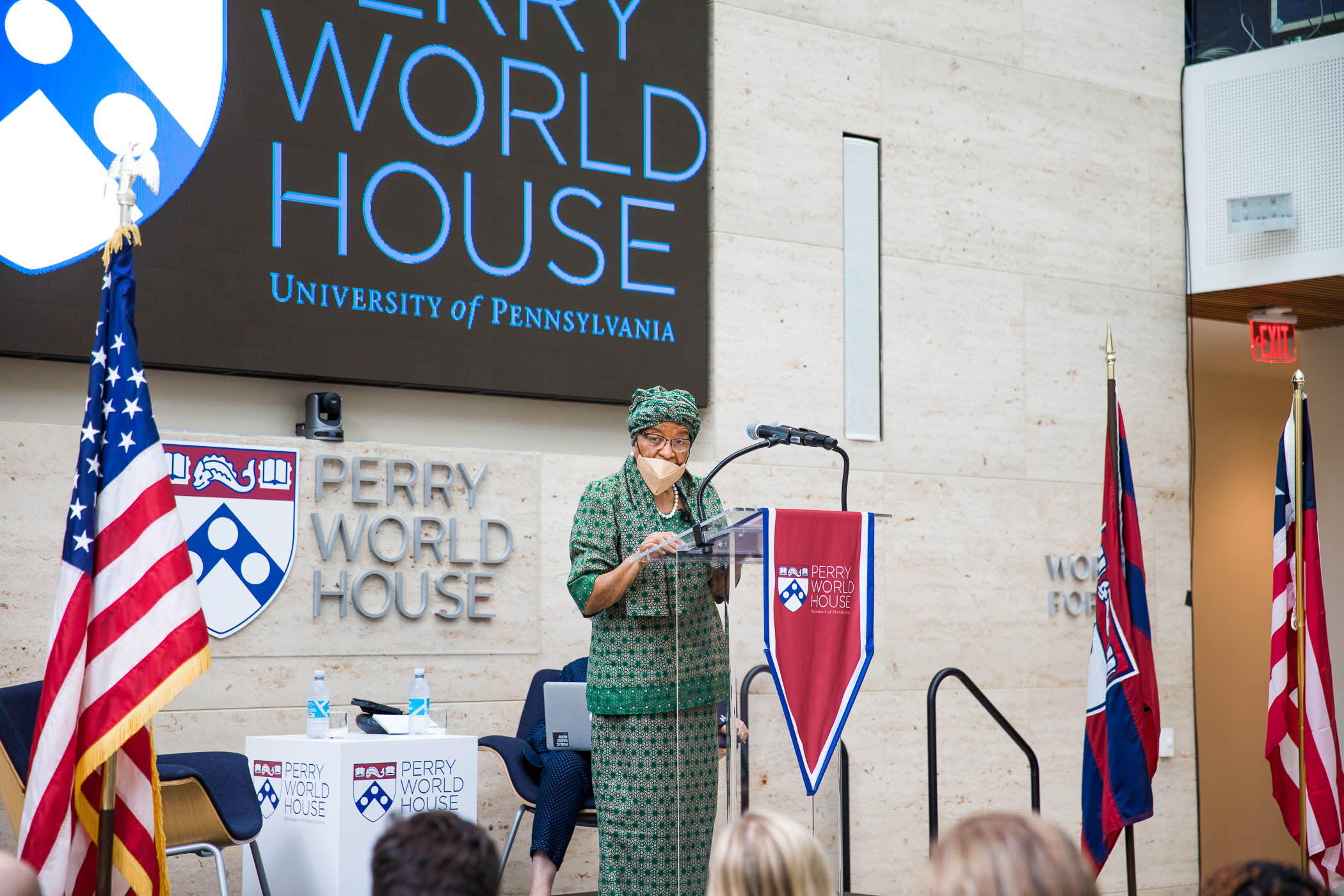 Former president of Liberia Ellen Johnson Sirleaf speaks at a podium with a sign reading Perry World House behind her