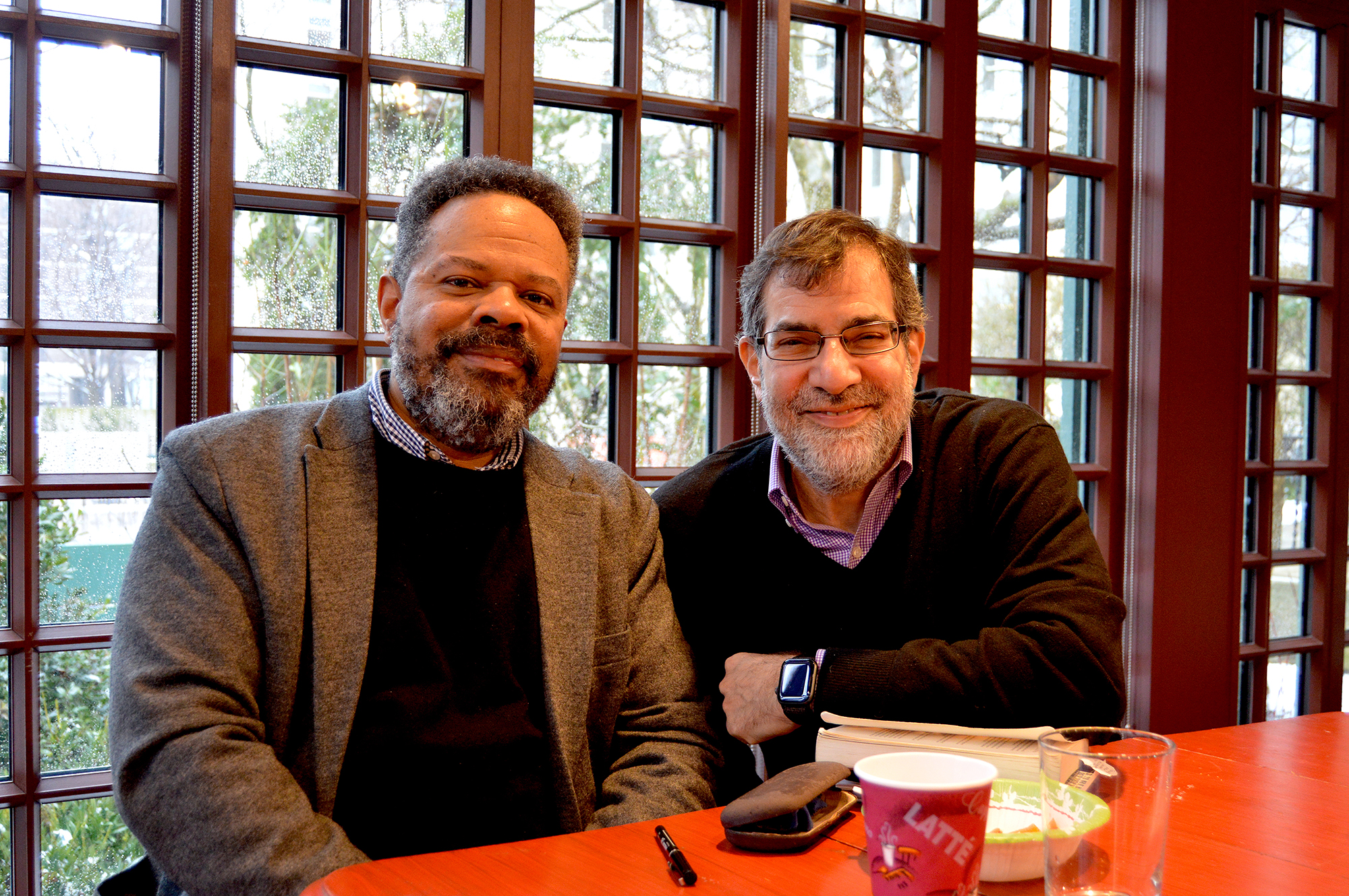 An author and Al Filreis smile at a table at the Kelly Writers House.