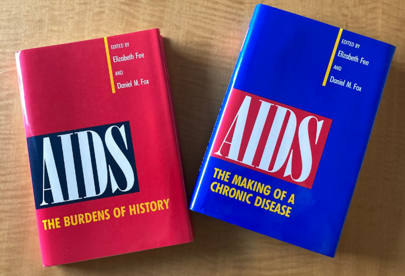 Two hardcover books on a table, “AIDS: The Burden of History” and “AIDS: The Making of a Chronic Disease.”