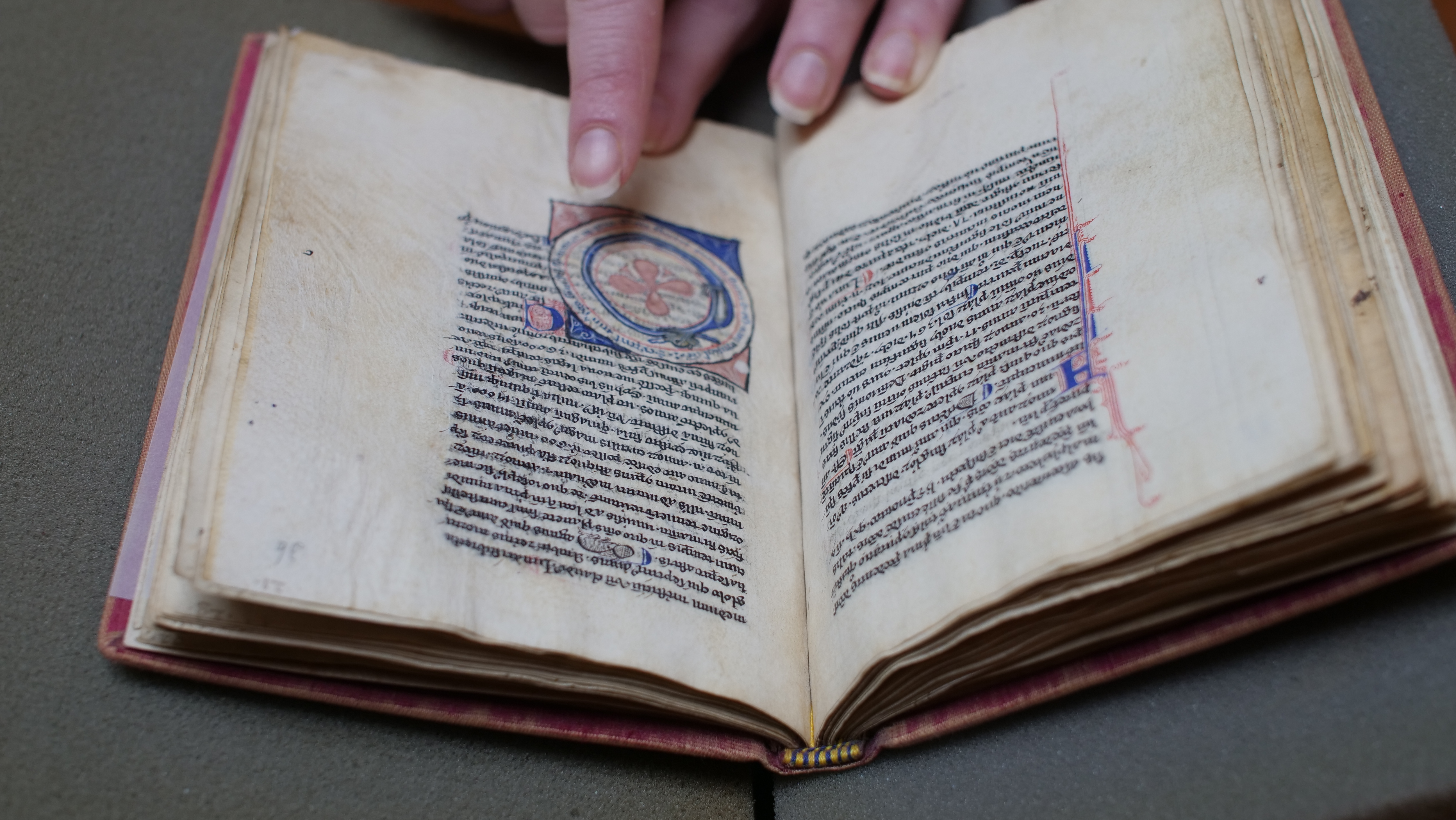 Hand pointing to text and an ancient symbol in an antique book.