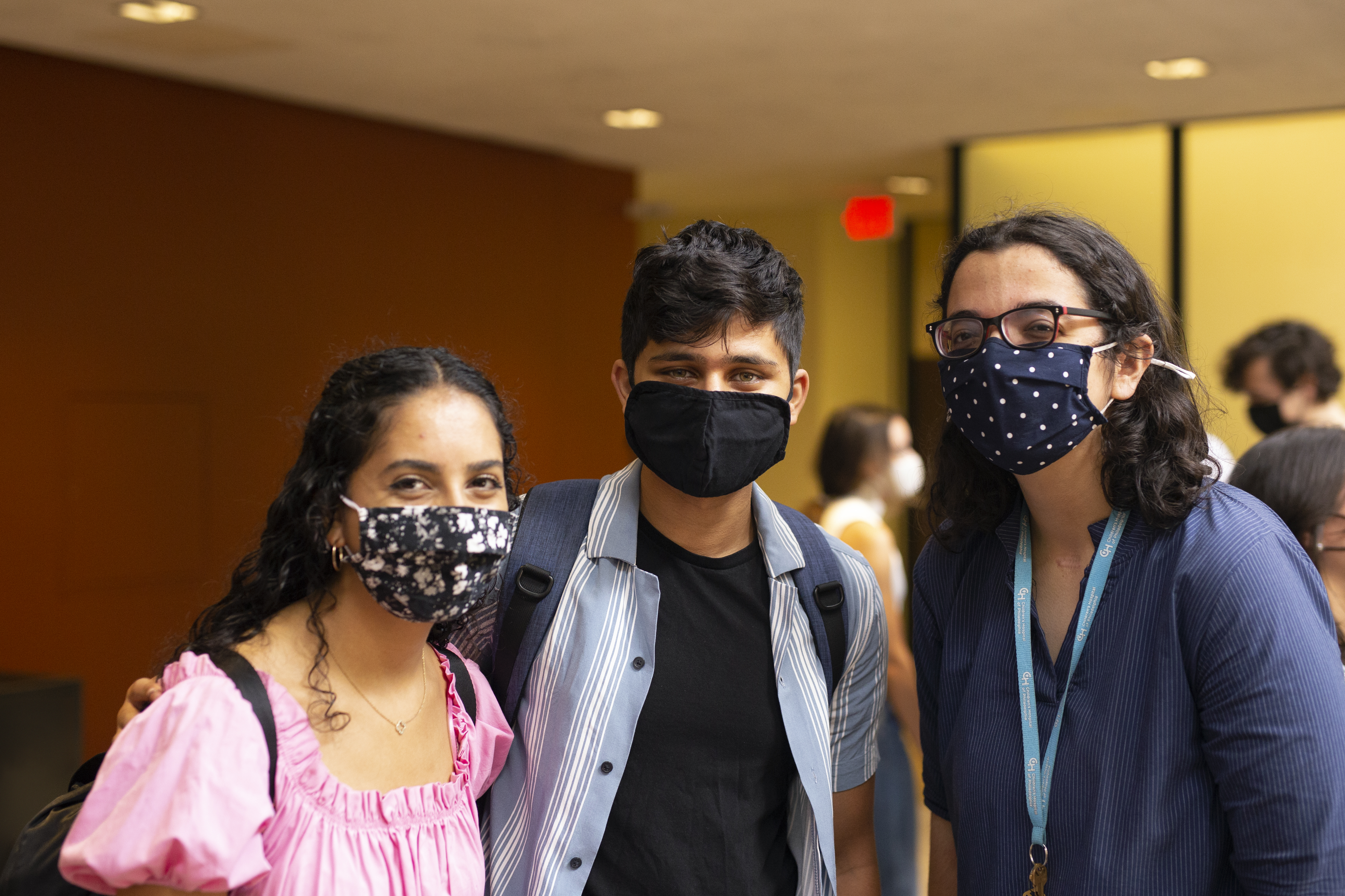 Three masked students pose together 