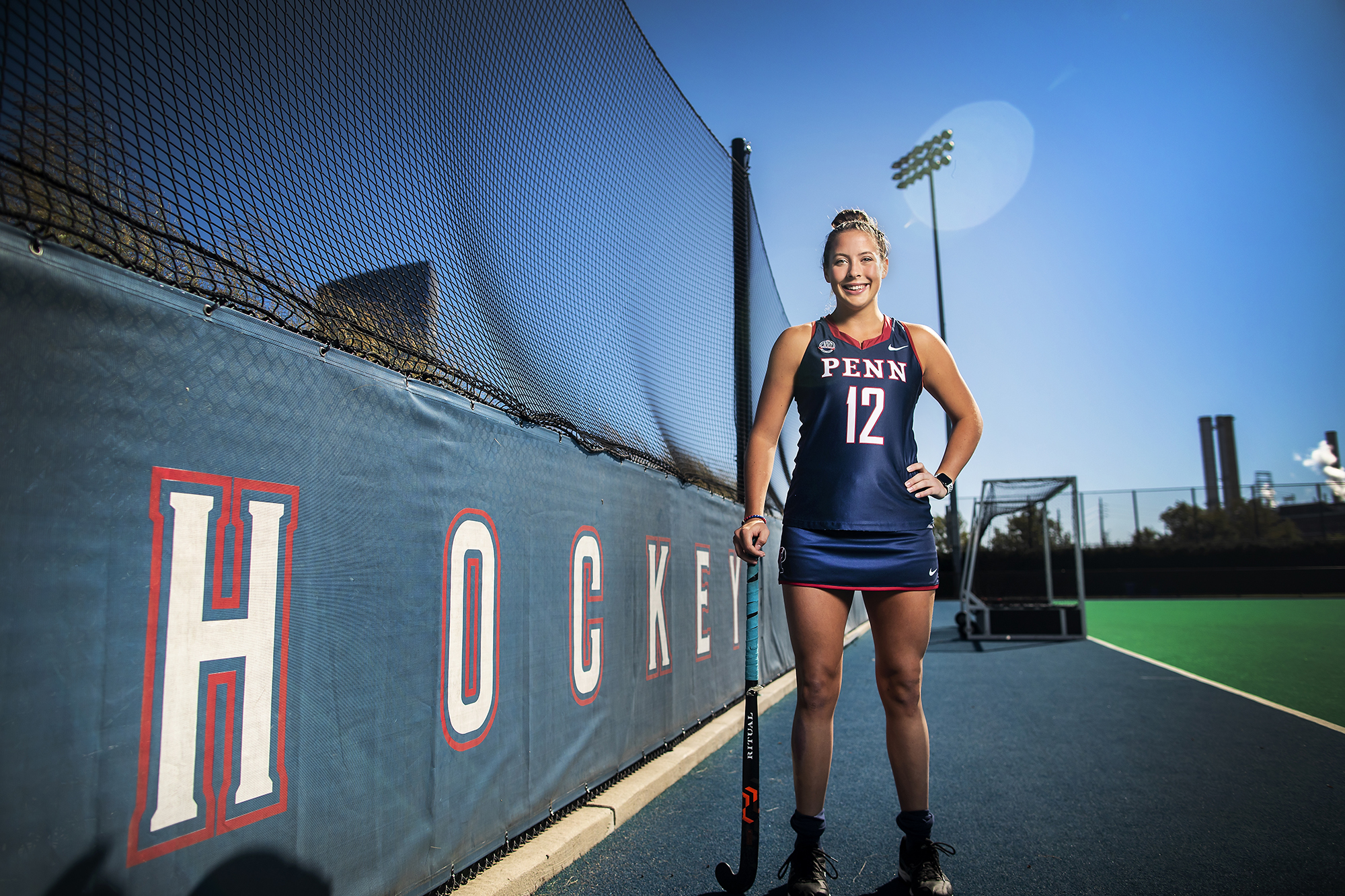 Banks smiles and holds her field hockey still while at Vagelos Field.