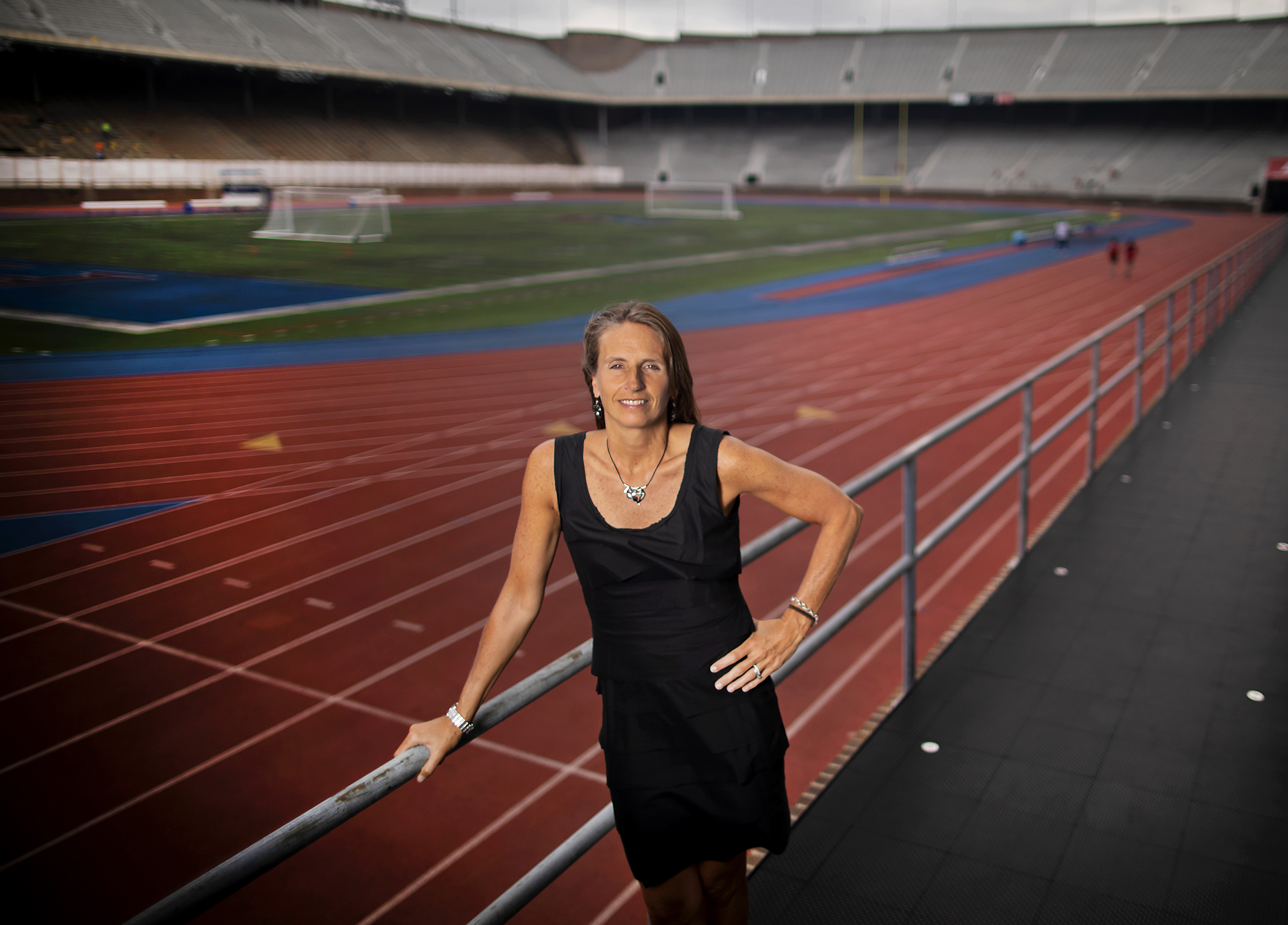 Wearing a black wear, Alanna Shanahan stands in the bleachers at Franklin Field, with her arm on the top railing.