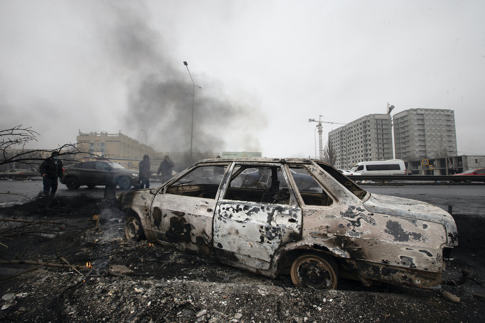 A burned four door sedan is seen on the charred ground in Almaty, Kazakhstan.