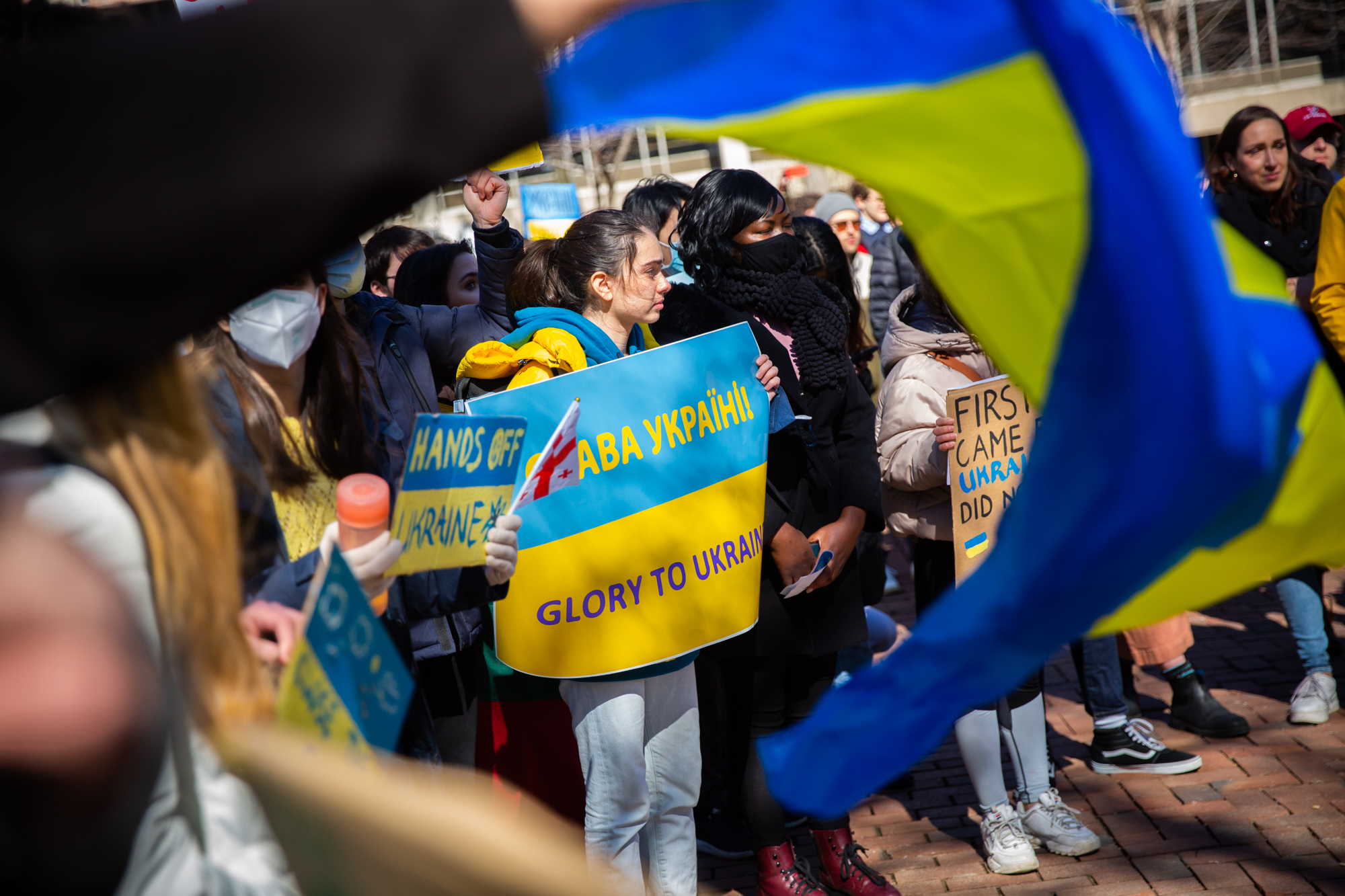 People on Penn’s campus holding Glory to Ukraine and Hands Off Ukraine signs.