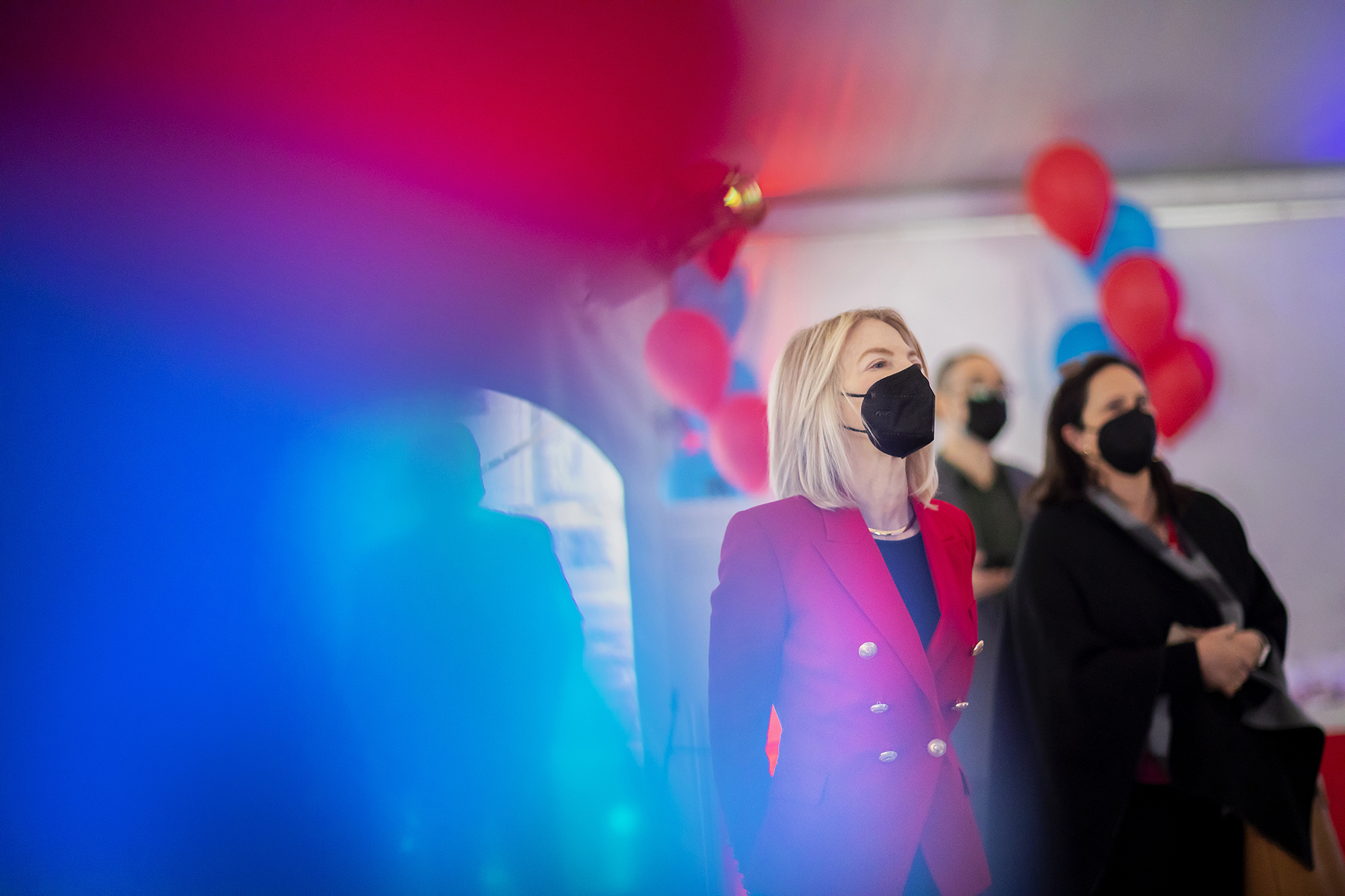 Penn President Amy Gutmann stands in a room surrounded by red and blue balloons.