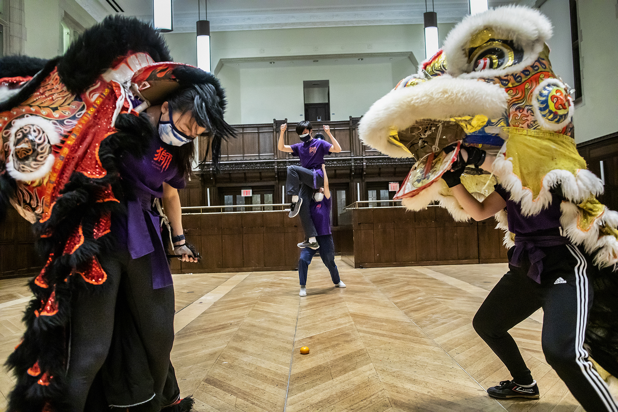 A pair of dancers are framed by two others inside lion costumes