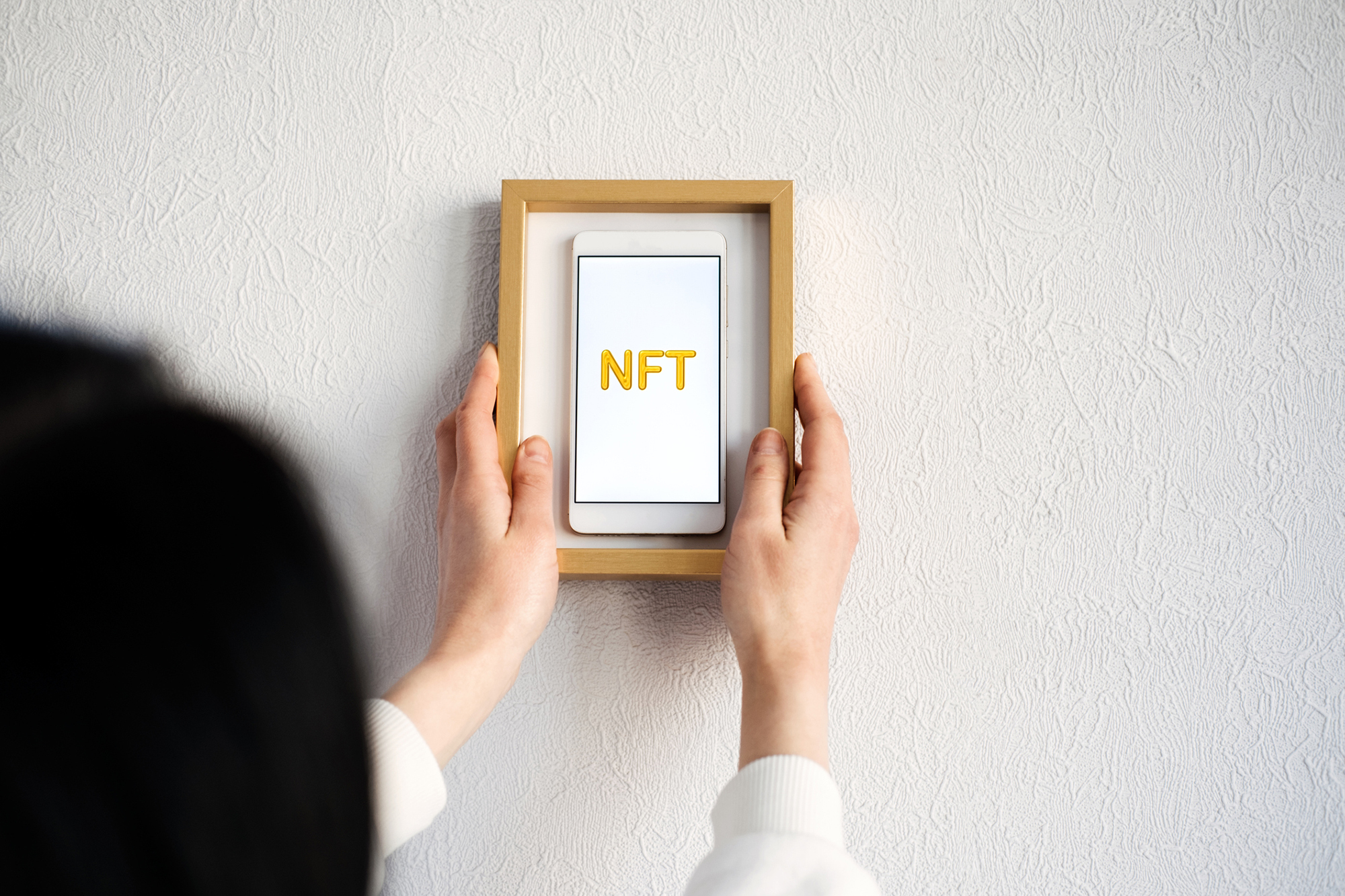 Picture frame of a phone with the letters 'NFT' written on it.
