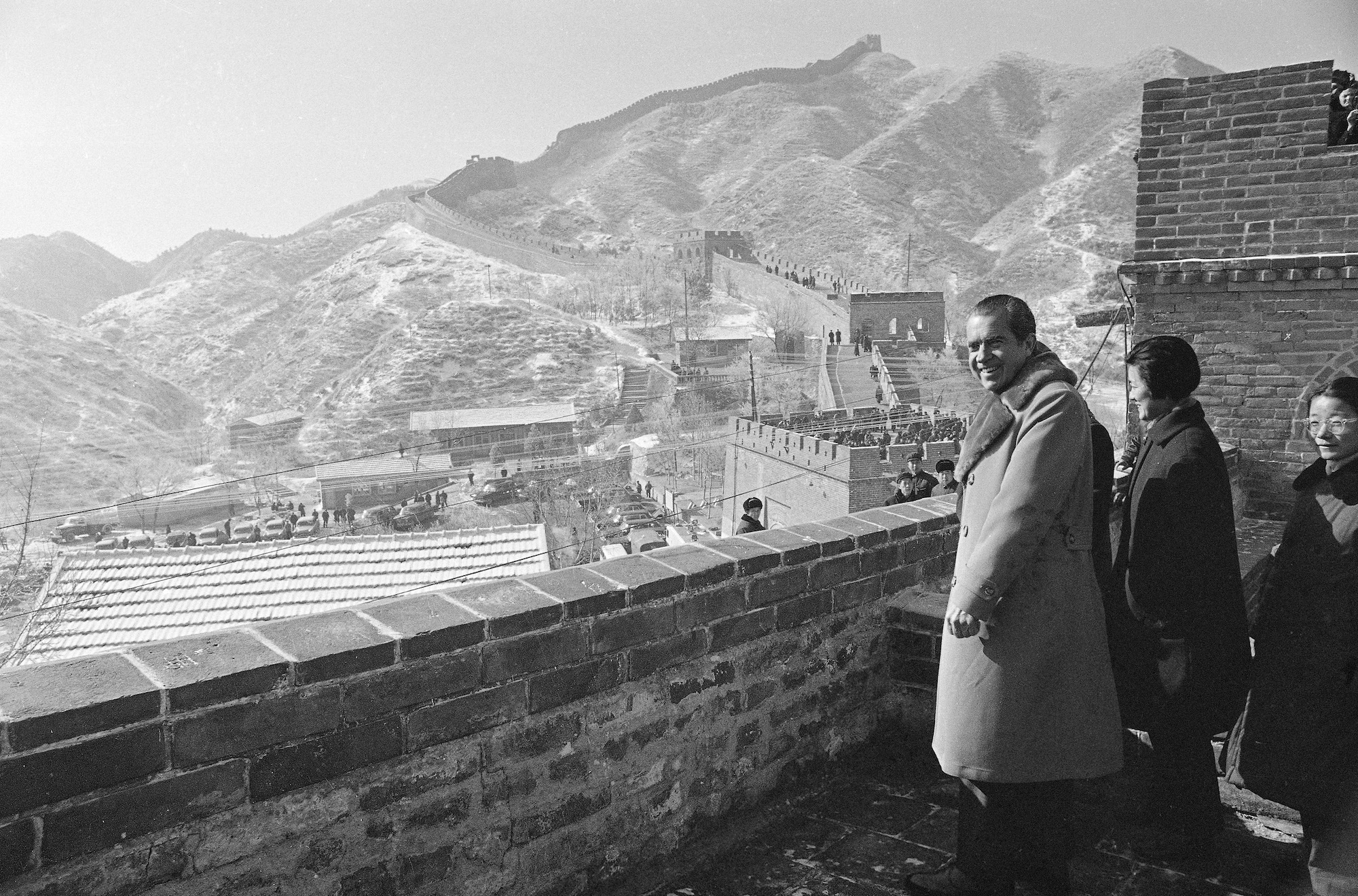 President Richard Nixon stands on the Great Wall of China, as the wall extends along the mountainside in the background