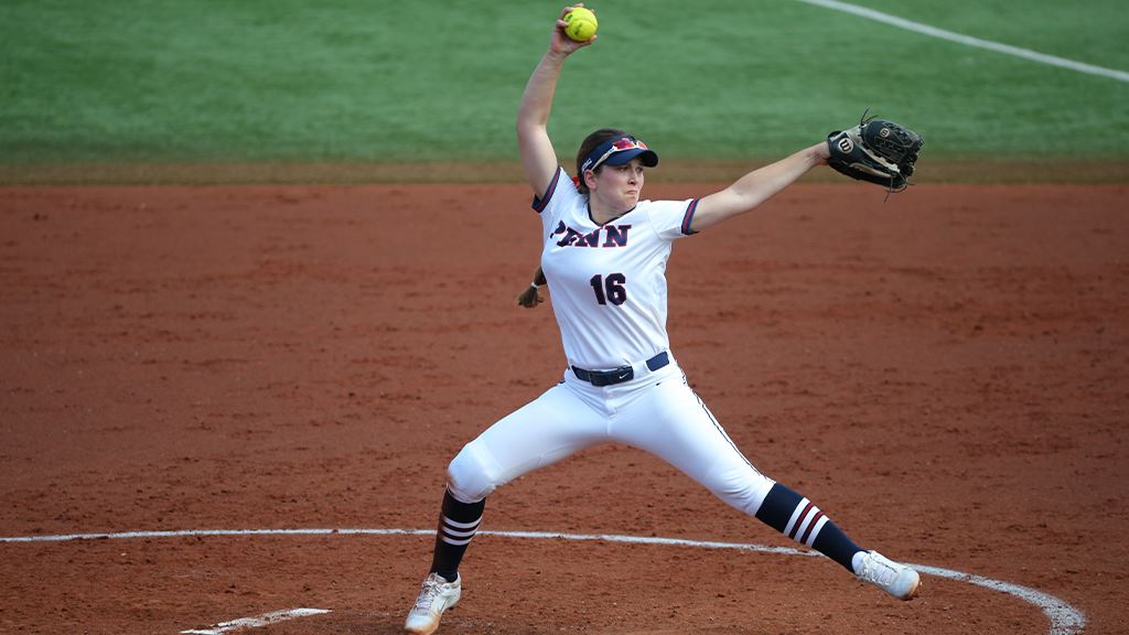 Bella Fiorentino, in her white Penn jersey, winds up to throw at pitch in the pitcher's circle.