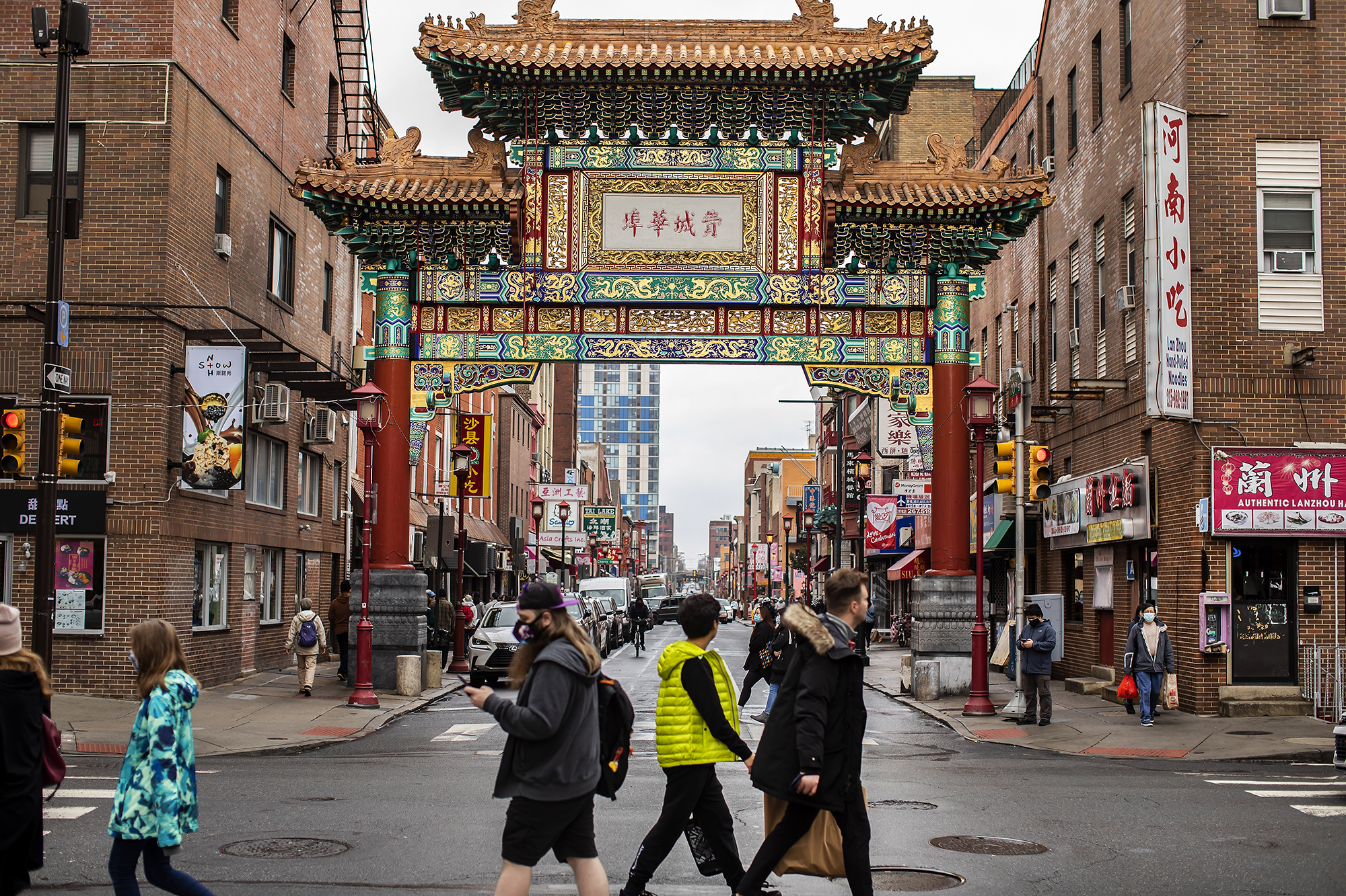 An image of the "Friendship Gate," with people walking by on a winter day
