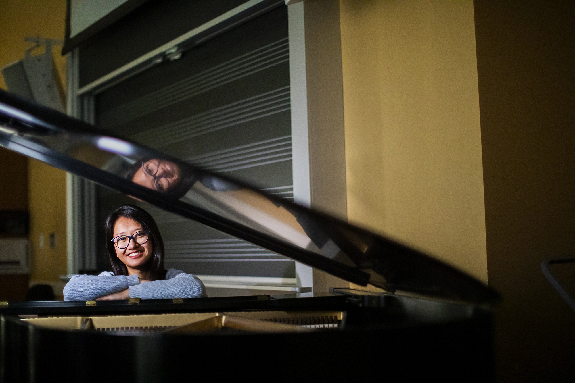 Student sitting at grand piano 