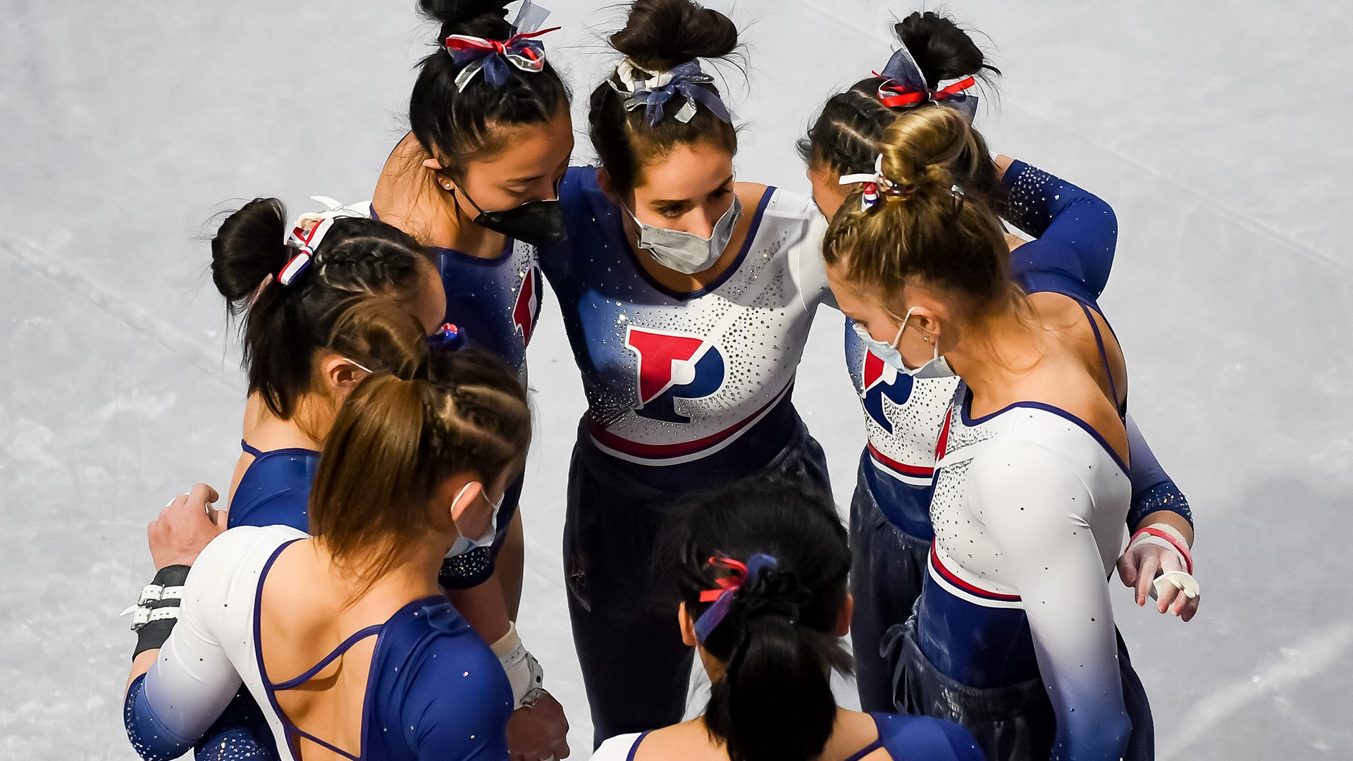 Members of the gymnastics team talk in a huddle.